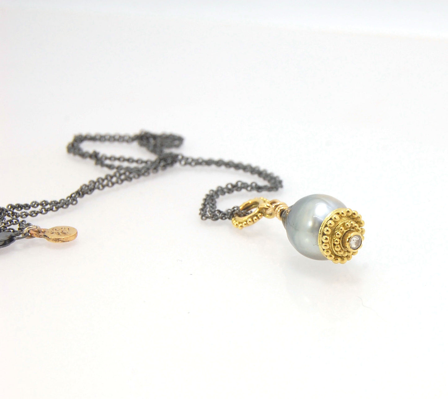 Baroque Grey Pearl with 18k gold Granulation and a Rosecut Diamond Ok this one is a stunner. 18k gold Granulated Dome with a 2.5 mm Rosecut Diamond and Granulated Bail pictured on an 18” peacock black oxidized Sterling Silver chain. Granulation is an anci