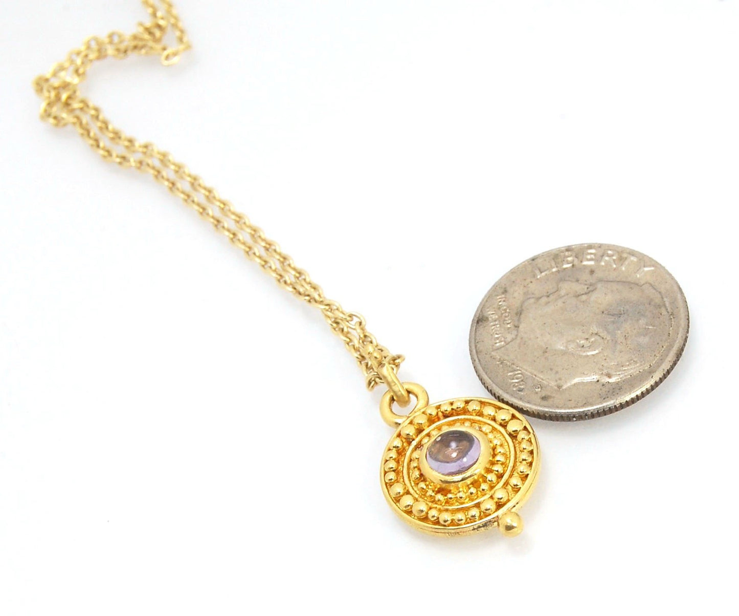 Amethyst 18k Gold Granulation Medallion This lovely light amethyst cabochon is surrounded by the 18k gold bezel setting and 18k gold granulation with a notched granulated bail. This classically inspired medallion looks like it could have come from buried