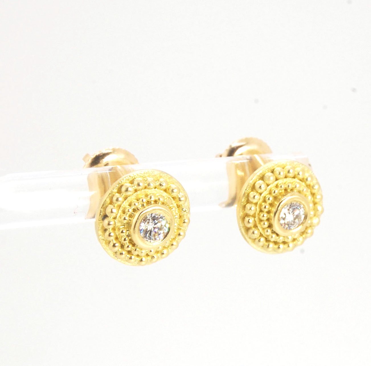 Diamond Disc Post Earrings - 18k Gold Granulation with 14k screw backs These Diamond Disc Stud Earrings are Classically-inspired 18k granulation. With 2 ethically-mined, .10ct , 3mm, Sl1, F+ round diamonds bezel-set in 18k a double ring of 18k gold granul