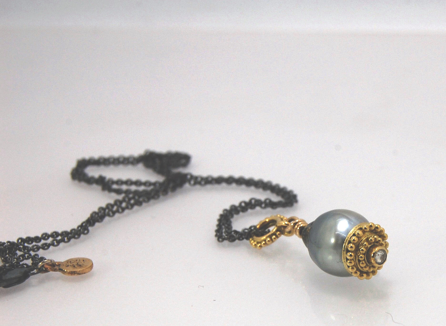 Baroque Grey Pearl with 18k gold Granulation and a Rosecut Diamond Ok this one is a stunner. 18k gold Granulated Dome with a 2.5 mm Rosecut Diamond and Granulated Bail pictured on an 18” peacock black oxidized Sterling Silver chain. Granulation is an anci