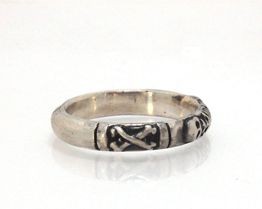 Oxidized Memento Mori Skeleton Ring - 4mm - Sterling Silver This is the middle width of my Memento Mori skeleton rings at 4mm wide. The Skeleton is flanked by crossed bones on one side and an hourglass on the other.Unlike my Enameled Memento Mori Rings, t