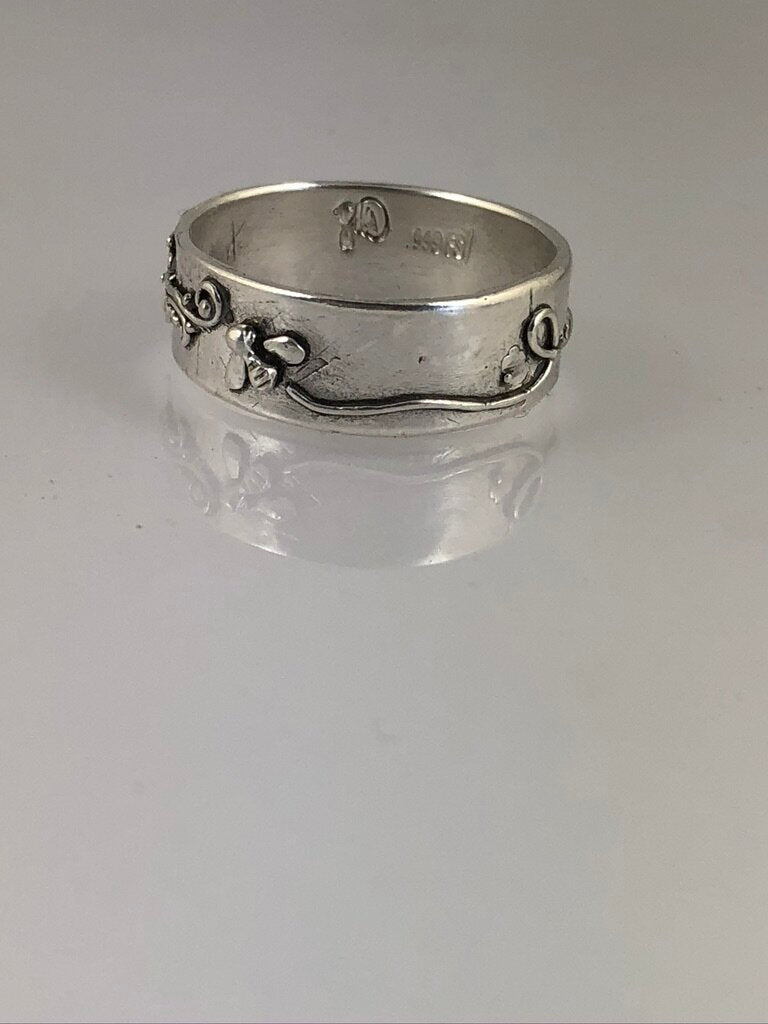 Pollinator Ring This Pollinator Band has a Bee and flower in tiny granulation. This band is a cast from a mold taken of a ring I granulated in fine silver. Granulation is an ancient fusing process that can only be done in certain highly pure metals that w