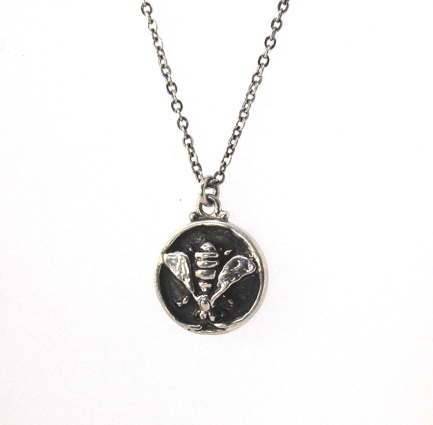 Bee Coin Necklace Carved in wax and cast using the lost-wax process in Sterling Silver, this bee coin was SO MUCH FUN to carve! I have made a mold and will be casting them to order. I inject the mold with wax and use that wax to cast using a lost-wax proc