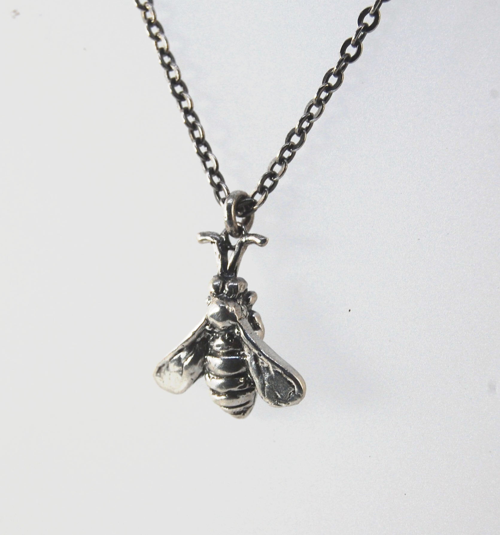 Bee Necklace in Sterling Silver Bee Necklace in Sterling Silver with a Sterling Chain and clasp.These bees were so fun to carve!Carved in wax and cast using a lost-wax process in Sterling Silver. I have made a mold of the first bee so I can make more bees