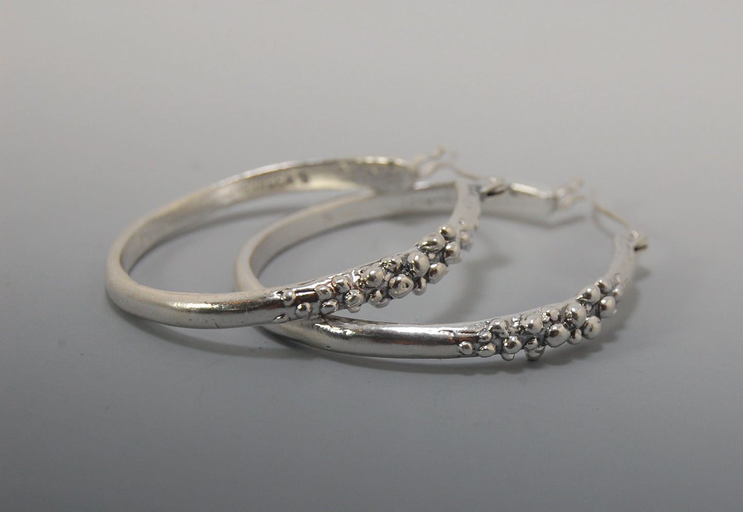 Bubble Hoops in Sterling These are great, unusual sterling silver bubble hoops. Carved in Wax and Cast in sterling silver with a lost wax process in my studio, these bubble beauties have a nice weight and the ear wire and clasp have a satisfying click. Da