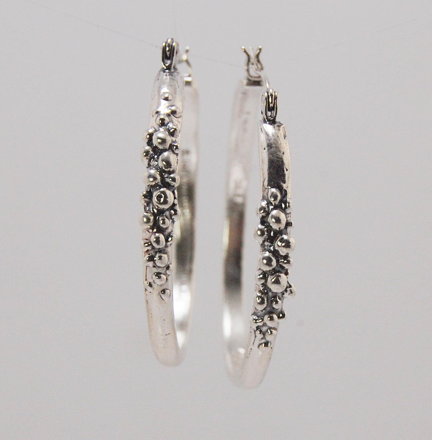 Bubble Hoops in Sterling These are great, unusual sterling silver bubble hoops. Carved in Wax and Cast in sterling silver with a lost wax process in my studio, these bubble beauties have a nice weight and the ear wire and clasp have a satisfying click. Da
