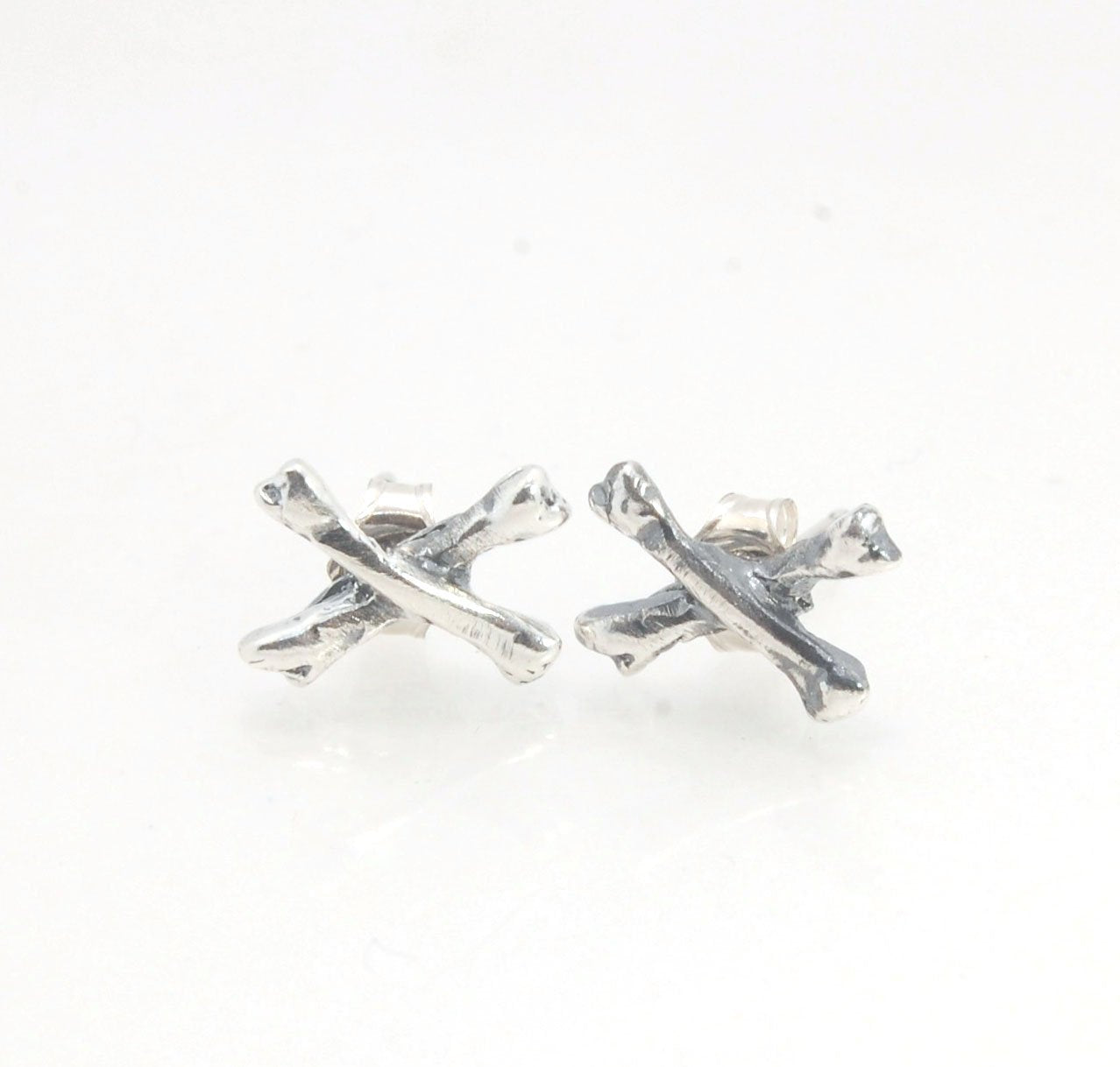Crossbones Studs These solid sterling silver Crossbones Studs are wax carved by hand and cast using the ancient process of Lost Wax to cast them in sterling silver. I then made a mold, which I can inject with wax and make wax copies of the Crossbones and