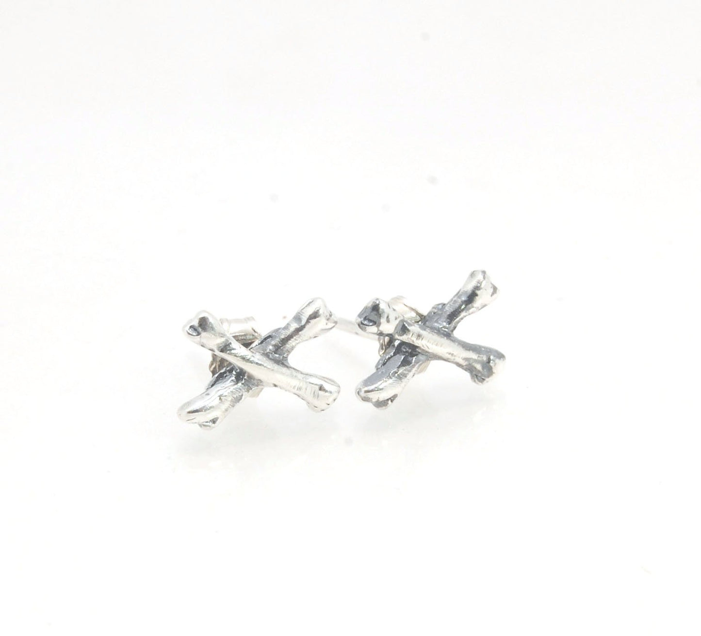 Crossbones Studs These solid sterling silver Crossbones Studs are wax carved by hand and cast using the ancient process of Lost Wax to cast them in sterling silver. I then made a mold, which I can inject with wax and make wax copies of the Crossbones and