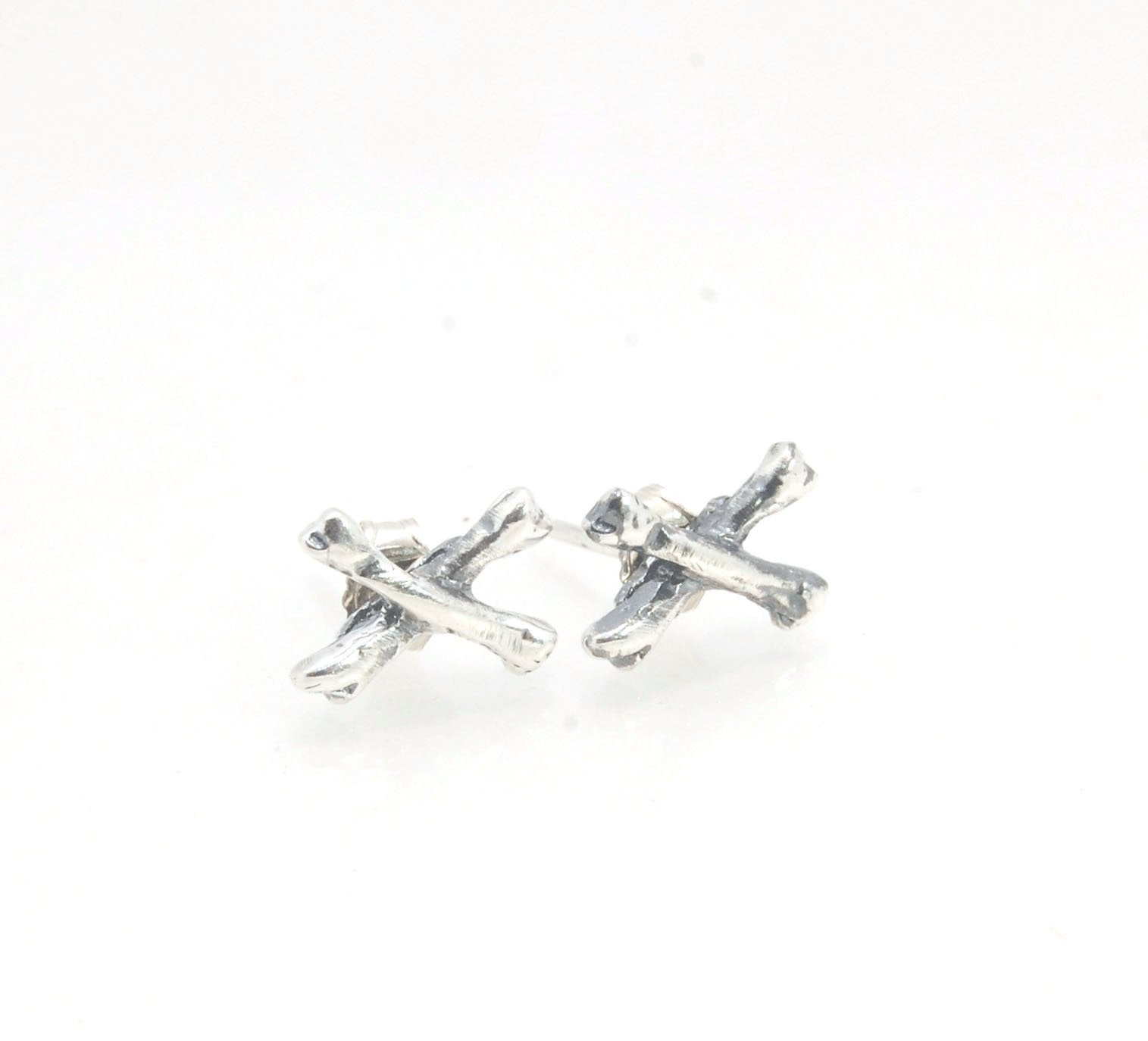 Crossbones Studs These solid sterling silver Crossbones Studs are wax carved by hand and cast using the ancient process of Lost Wax to cast them in sterling silver. I then made a mold, which I can inject with wax and make wax copies of the Crossbones and