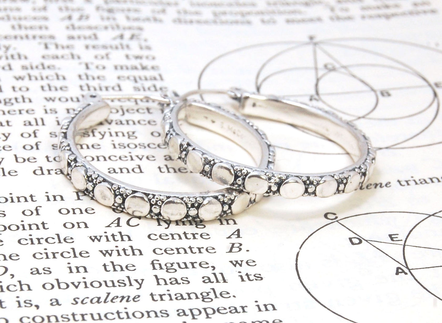 Disc Hoops - Sterling in 3 sizes These Hoops are made from a Disc pattern with heavy granules and ingot slices and have a hoop catch with a satisfying snap and come in three sizes:Large - 4mm wide and 1.25” in diameterMedium - 4mm wide and .75” in diamete
