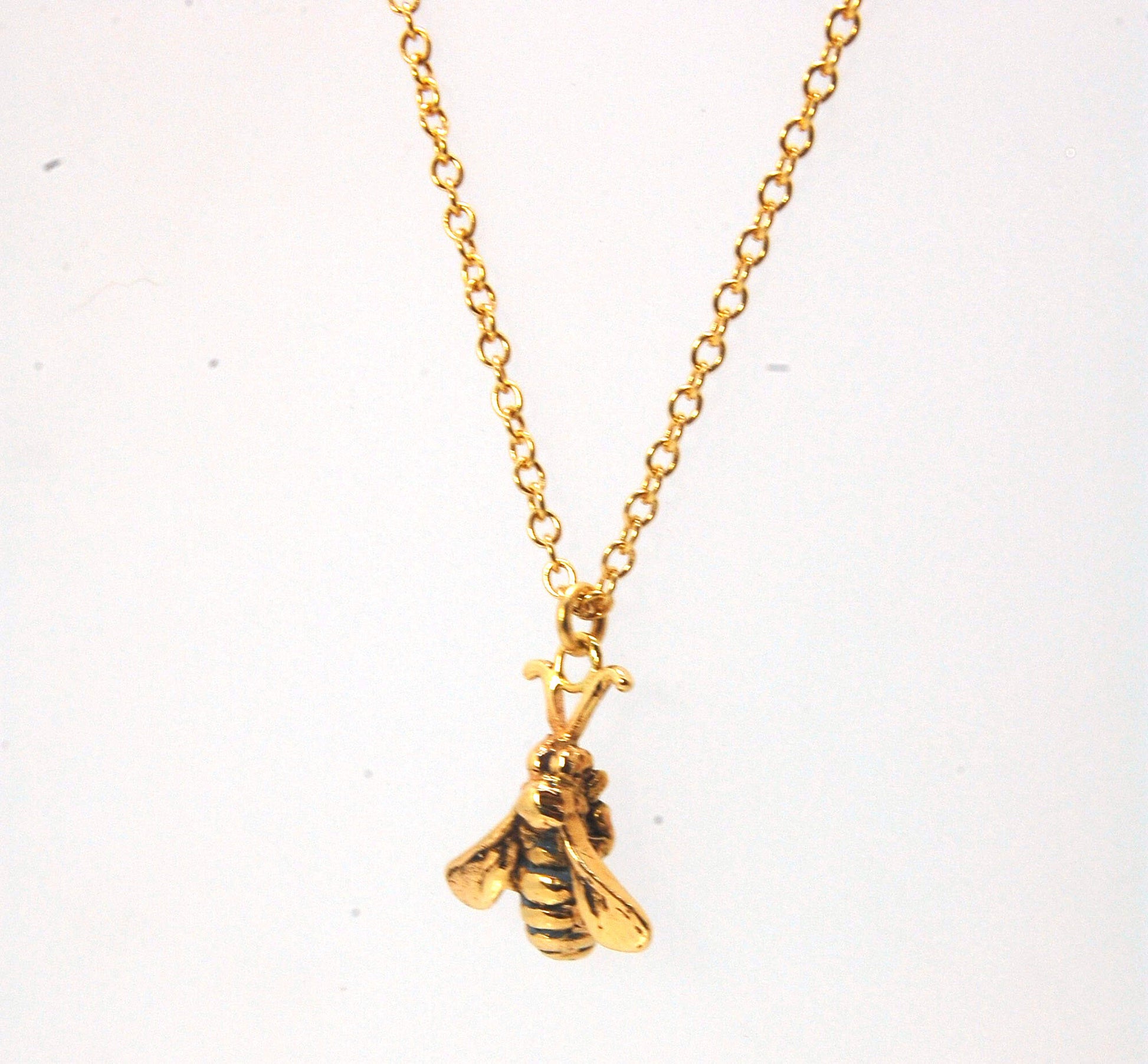 Bee Pendant in 14k gold These bees were so fun to carve!Carved in wax and cast using a lost-wax process in 14k gold. I finish the bee with a dark patina in the recess and attach an oxidized sterling chain length of your specification. I then give the bee