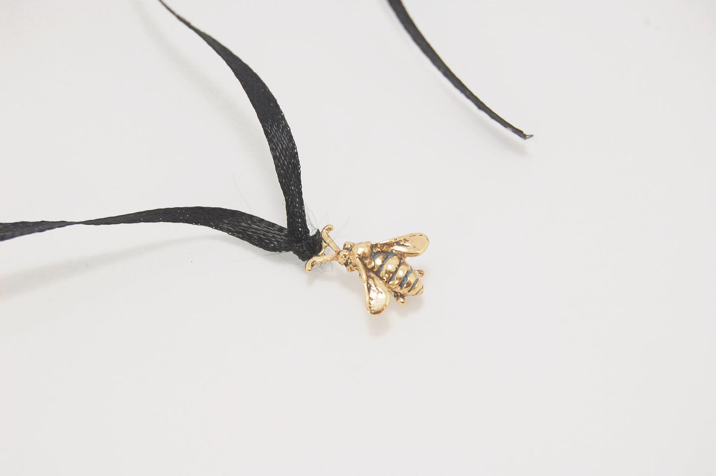 Bee Pendant in 14k gold These bees were so fun to carve!Carved in wax and cast using a lost-wax process in 14k gold. I finish the bee with a dark patina in the recess and attach an oxidized sterling chain length of your specification. I then give the bee