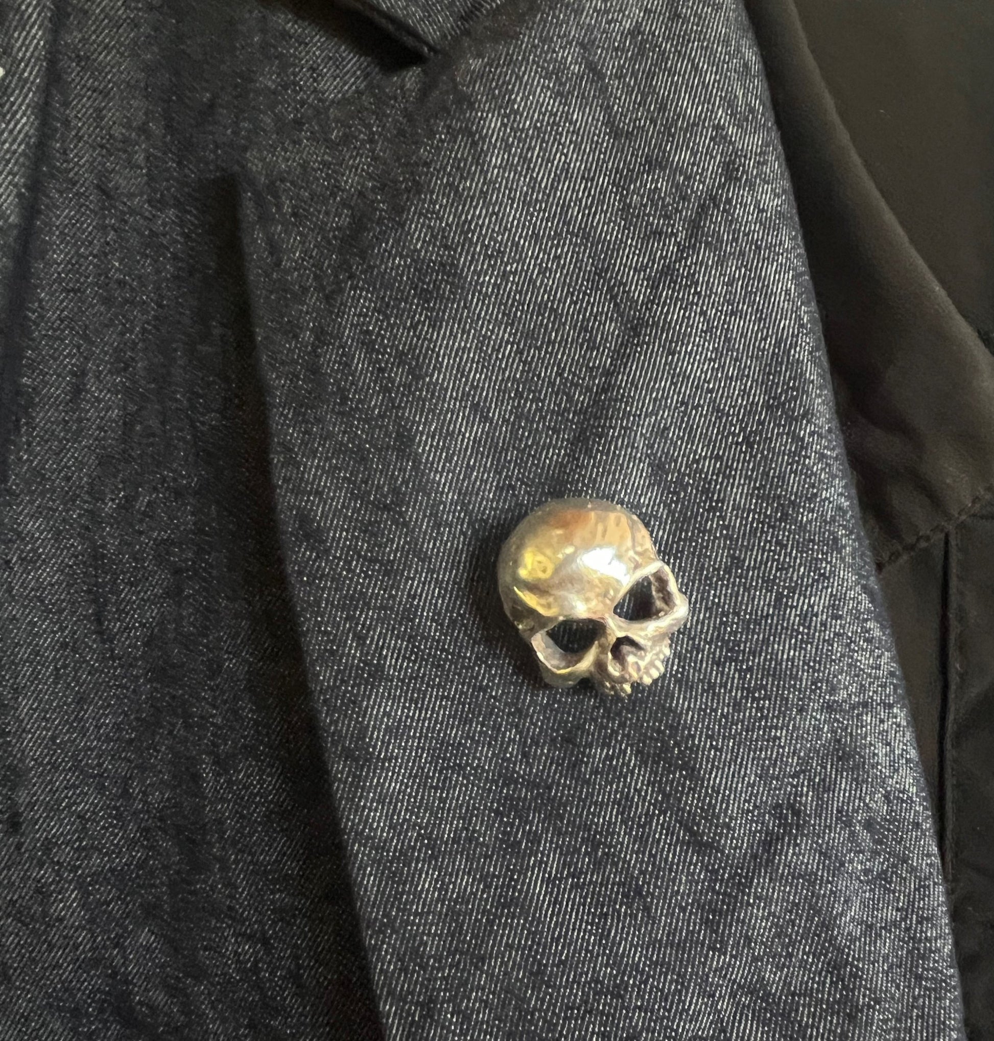 Through the Veil Darkly Skull Face Pin This Through the Veil Darkly Skull Face pin in Sterling Silver has a lot of expression and a nice weight with a hinged pin stem and clasp. It’s not too big or too small or too heavy. It will look great on your sweate