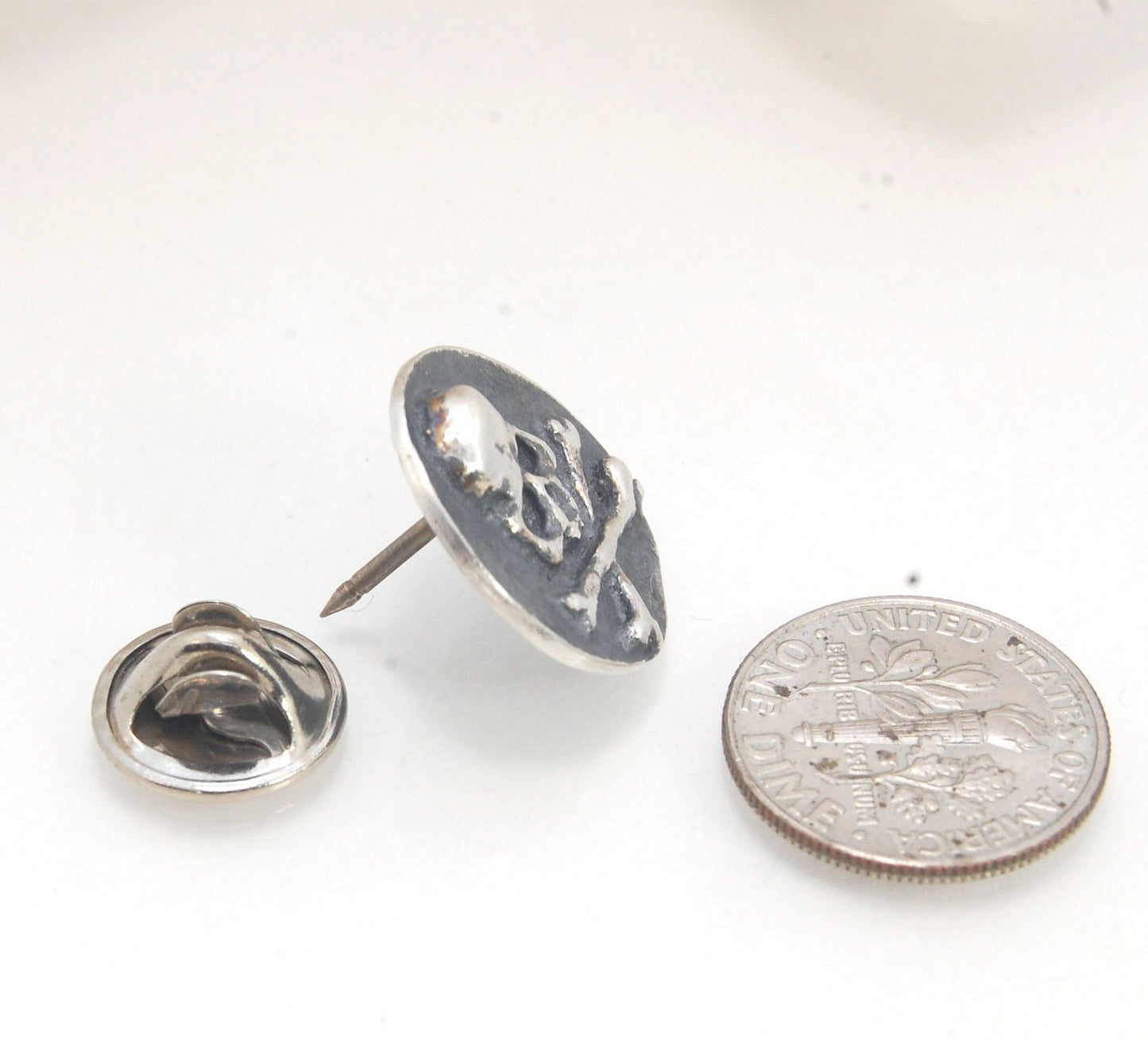 Skullbones Coin Lapel Pin These solid sterling silver SkullBones Coin Lapel Pin can also be worn as a Tie Tack. This Skullbones Coin is wax carved by hand and cast using the ancient process of Lost Wax to cast them in sterling silver. I then made a mold,