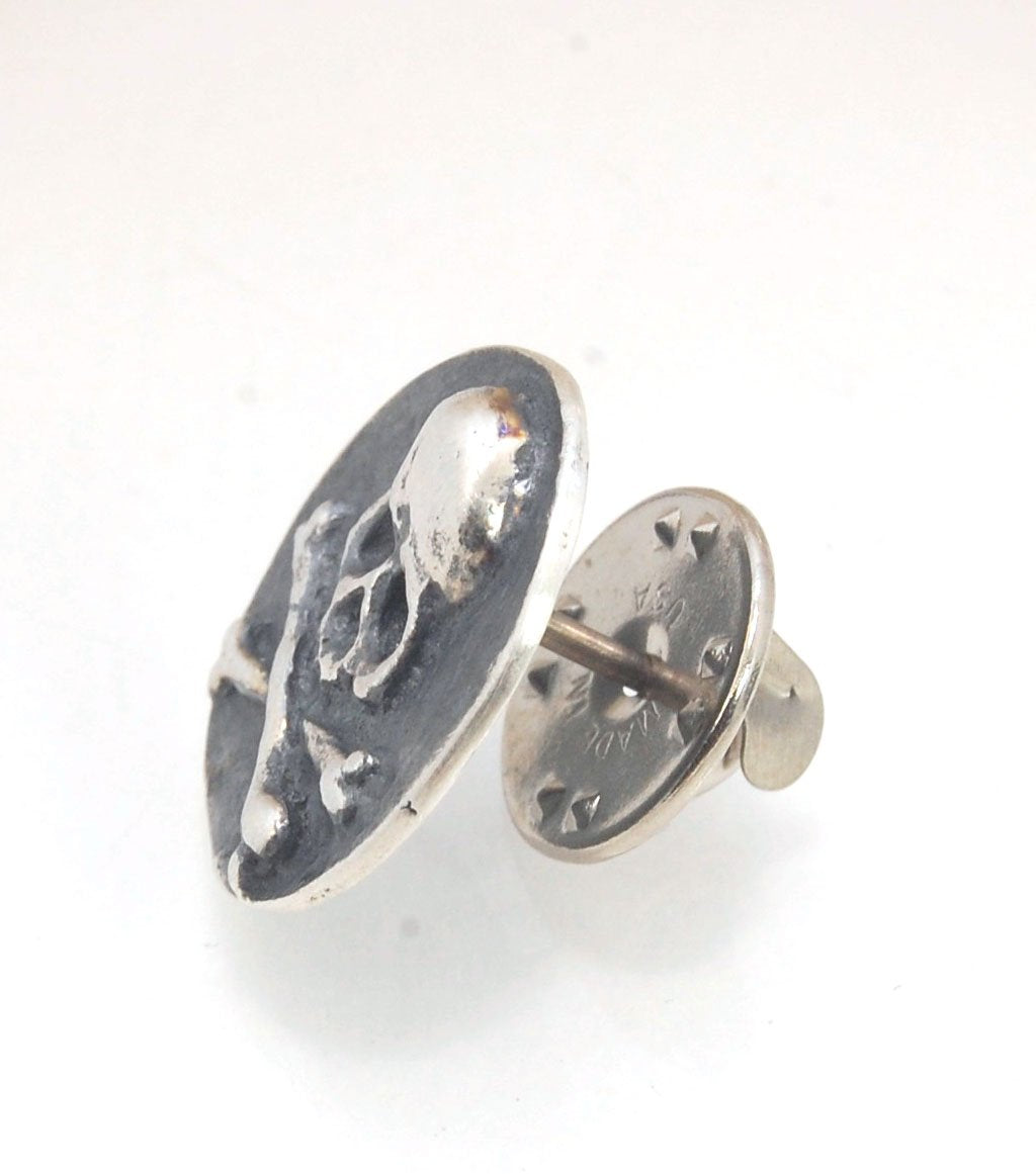 Skullbones Coin Lapel Pin These solid sterling silver SkullBones Coin Lapel Pin can also be worn as a Tie Tack. This Skullbones Coin is wax carved by hand and cast using the ancient process of Lost Wax to cast them in sterling silver. I then made a mold,