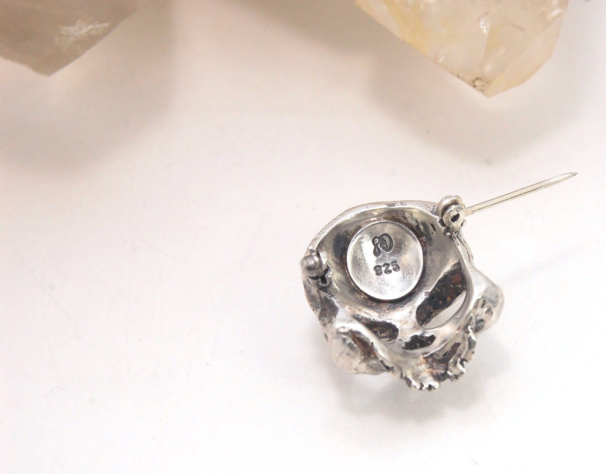 Through the Veil Darkly Skull Face Pin This Through the Veil Darkly Skull Face pin in Sterling Silver has a lot of expression and a nice weight with a hinged pin stem and clasp. It’s not too big or too small or too heavy. It will look great on your sweate