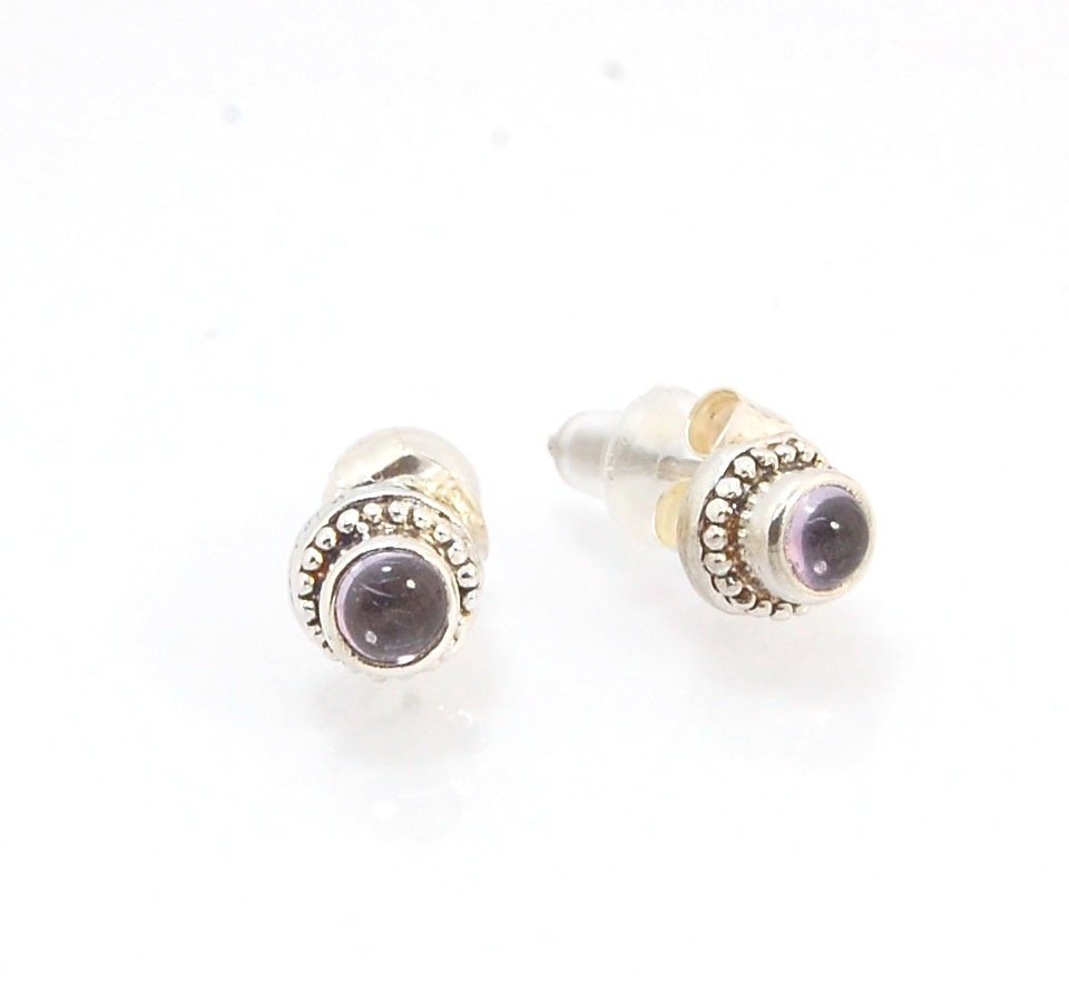 Amethyst Tiny Post Earrings in Sterling Silver These are tiny bezel settings I created using the ancient process of granulation. I then made a mold of it and injected the mold with wax and used that wax to create a Sterling Silver version of these granula