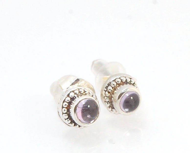 Amethyst Tiny Post Earrings in Sterling Silver These are tiny bezel settings I created using the ancient process of granulation. I then made a mold of it and injected the mold with wax and used that wax to create a Sterling Silver version of these granula