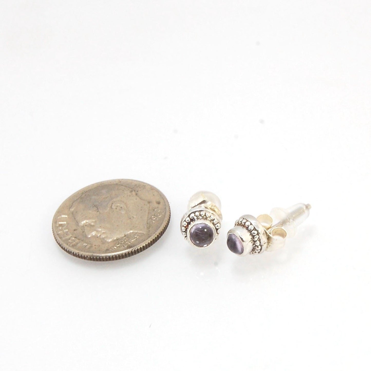 Amethyst Tiny Post Earrings in Sterling Silver These are tiny bezel settings I created using the ancient process of granulation. I then made a mold of it and injected the mold with wax and used that wax to create a Sterling Silver version of these granula
