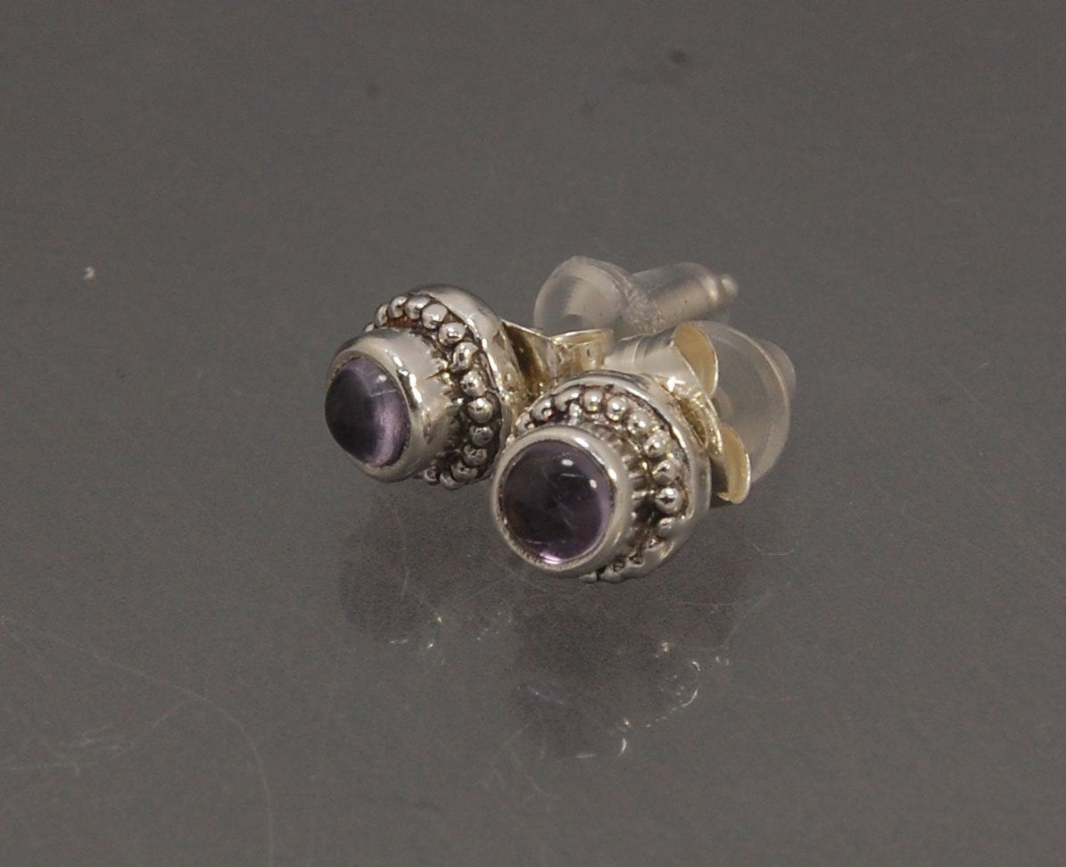 Amethyst Tiny Post Earrings in Sterling Silver These are tiny bezel settings I created using the ancient process of granulation. I then made a mold of it and injected the mold with wax and used that wax to create a Sterling Silver version of these granula