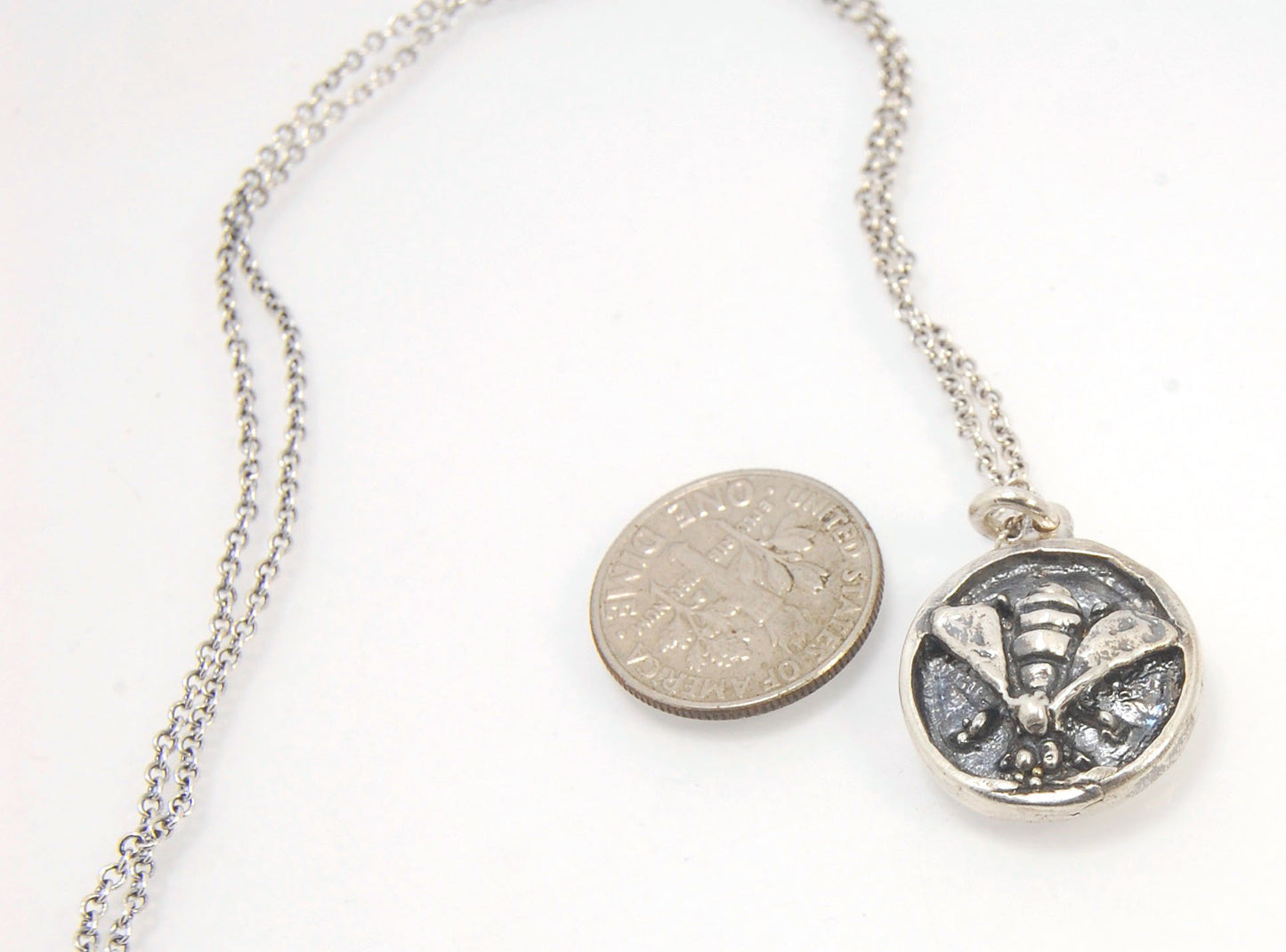 Bee Coin Necklace Carved in wax and cast using the lost-wax process in Sterling Silver, this bee coin was SO MUCH FUN to carve! I have made a mold and will be casting them to order. I inject the mold with wax and use that wax to cast using a lost-wax proc