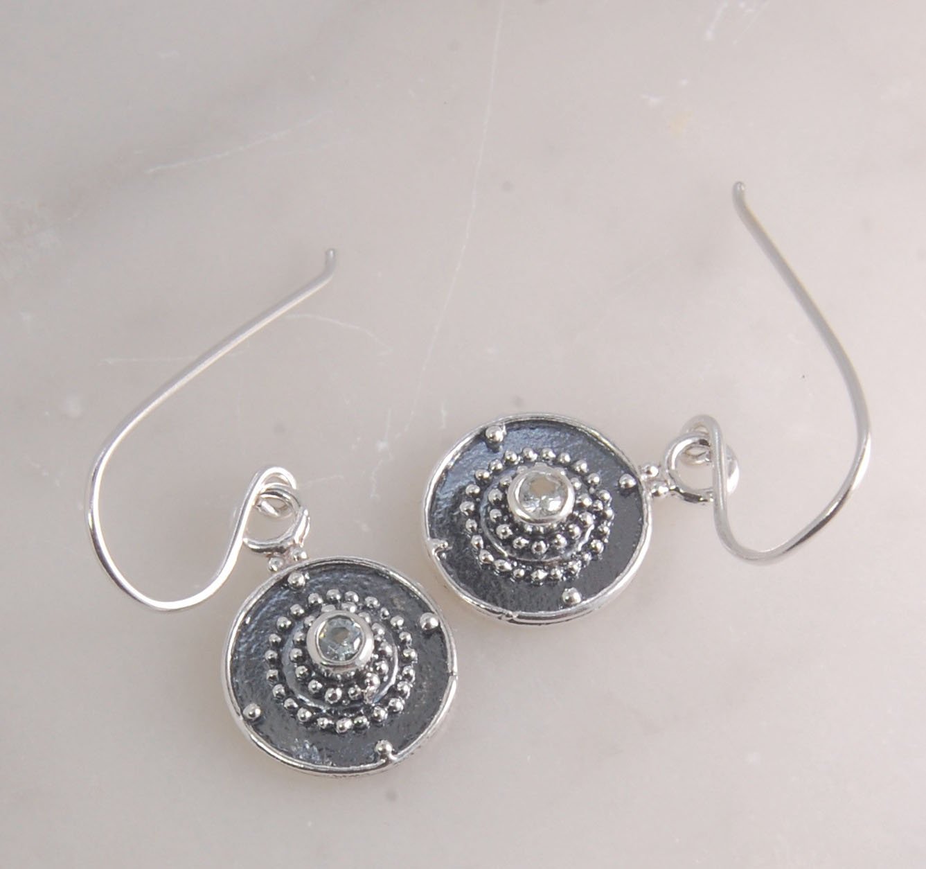 Dangle Shield Earrings in Sterling with Pink Garnet, Red Garnet, Blue Topaz, Peridot, or Amethyst These terrific shield earrings are cast from a granulated original. and is cast using the lost wax process. You can choose which stone to set in your sterlin