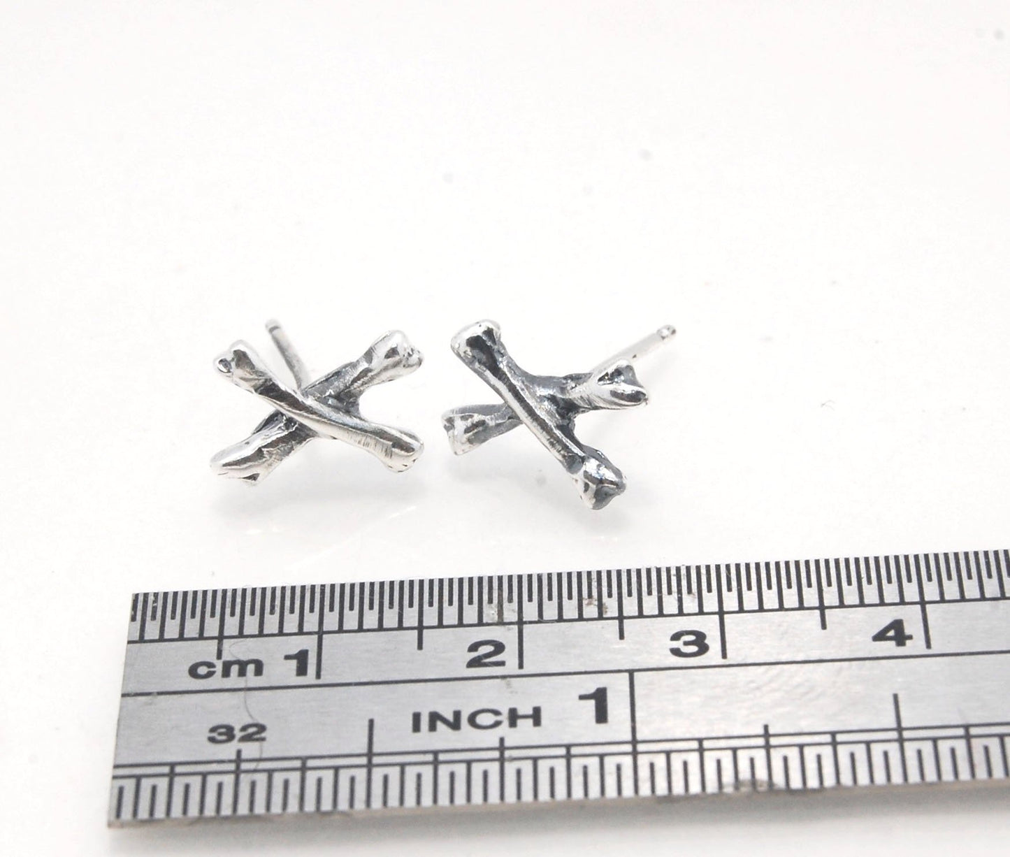 Crossbones Studs These solid sterling silver Crossbones Studs are wax carved by hand and cast using the ancient process of Lost Wax to cast them in sterling silver. I then made a mold, which I can inject with wax and make wax copies of the Crossbones and