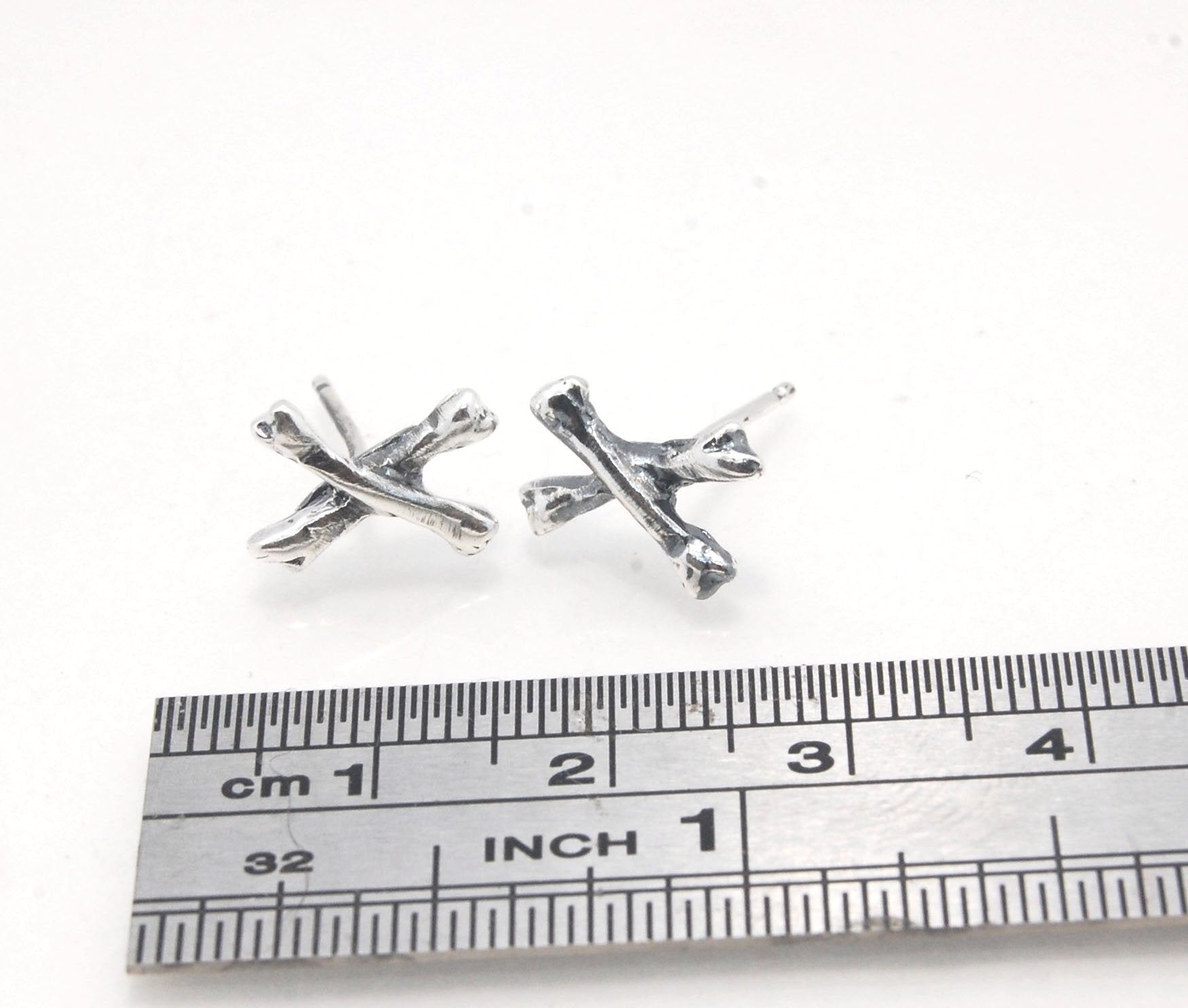 Crossbones Studs These solid sterling silver Crossbones Studs are wax carved by hand and cast using the ancient process of Lost Wax to cast them in sterling silver. I then made a mold, which I can inject with wax and make wax copies of the Crossbones and