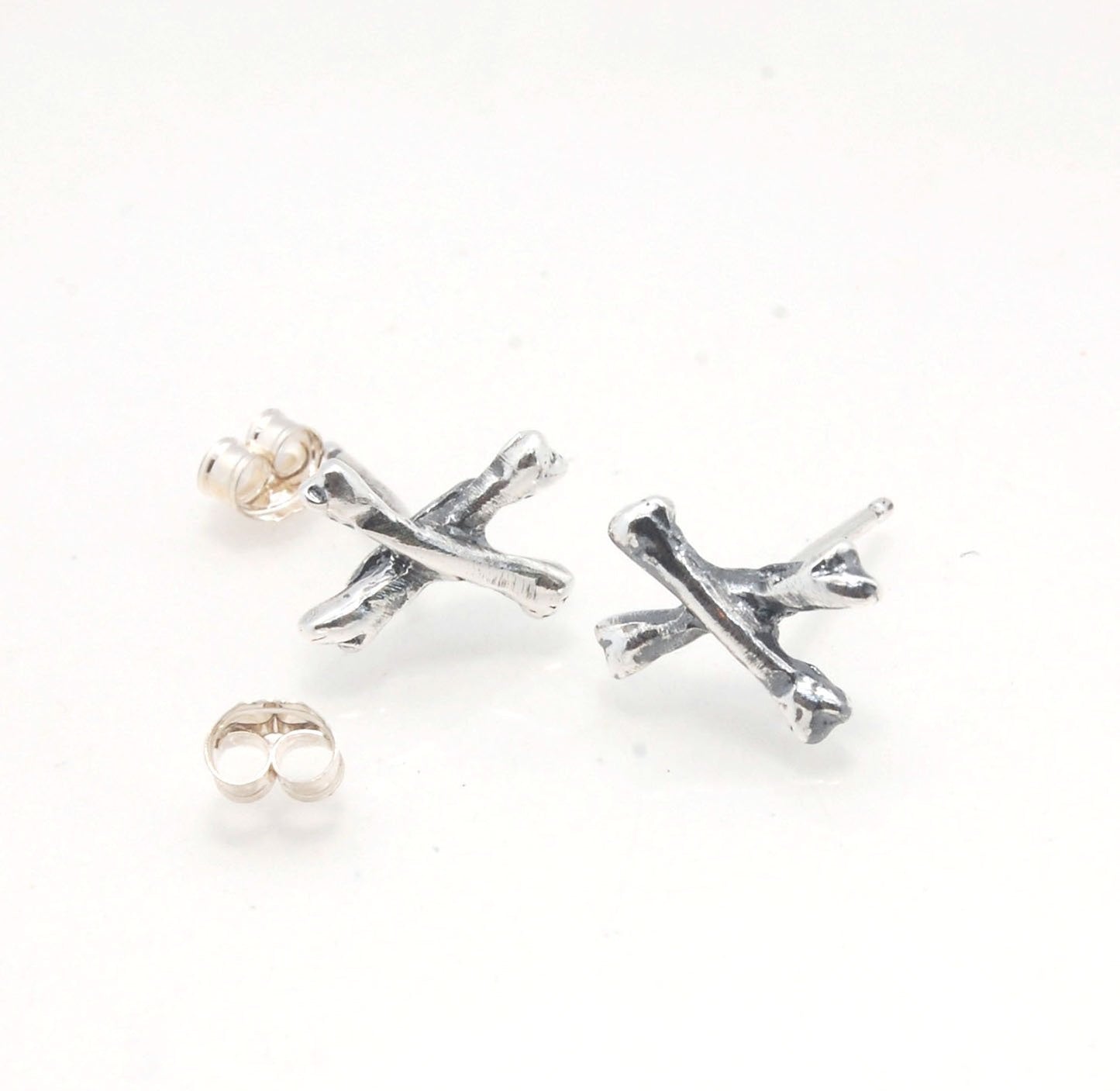 Crossbones Studs These solid sterling silver Crossbones Studs are wax carved by hand and cast using the ancient process of Lost Wax to cast them in sterling silver. I then made a mold, which I can inject with wax and make wax copies of the Crossbones and
