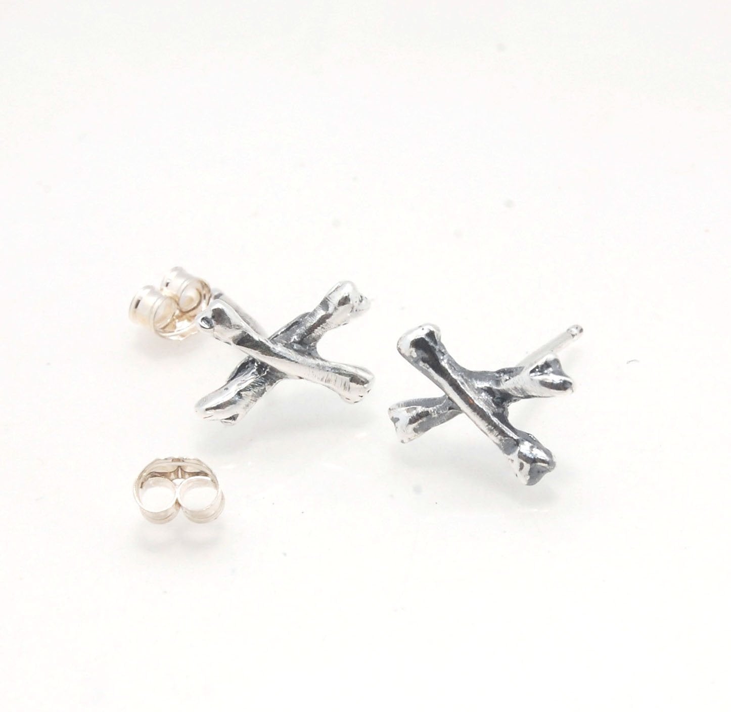 Crossbones Studs These solid sterling silver Crossbones Studs are wax carved by hand and cast using the ancient process of Lost Wax to cast them in sterling silver. I then made a mold, which I can inject with wax and make wax copies of the Crossbones and