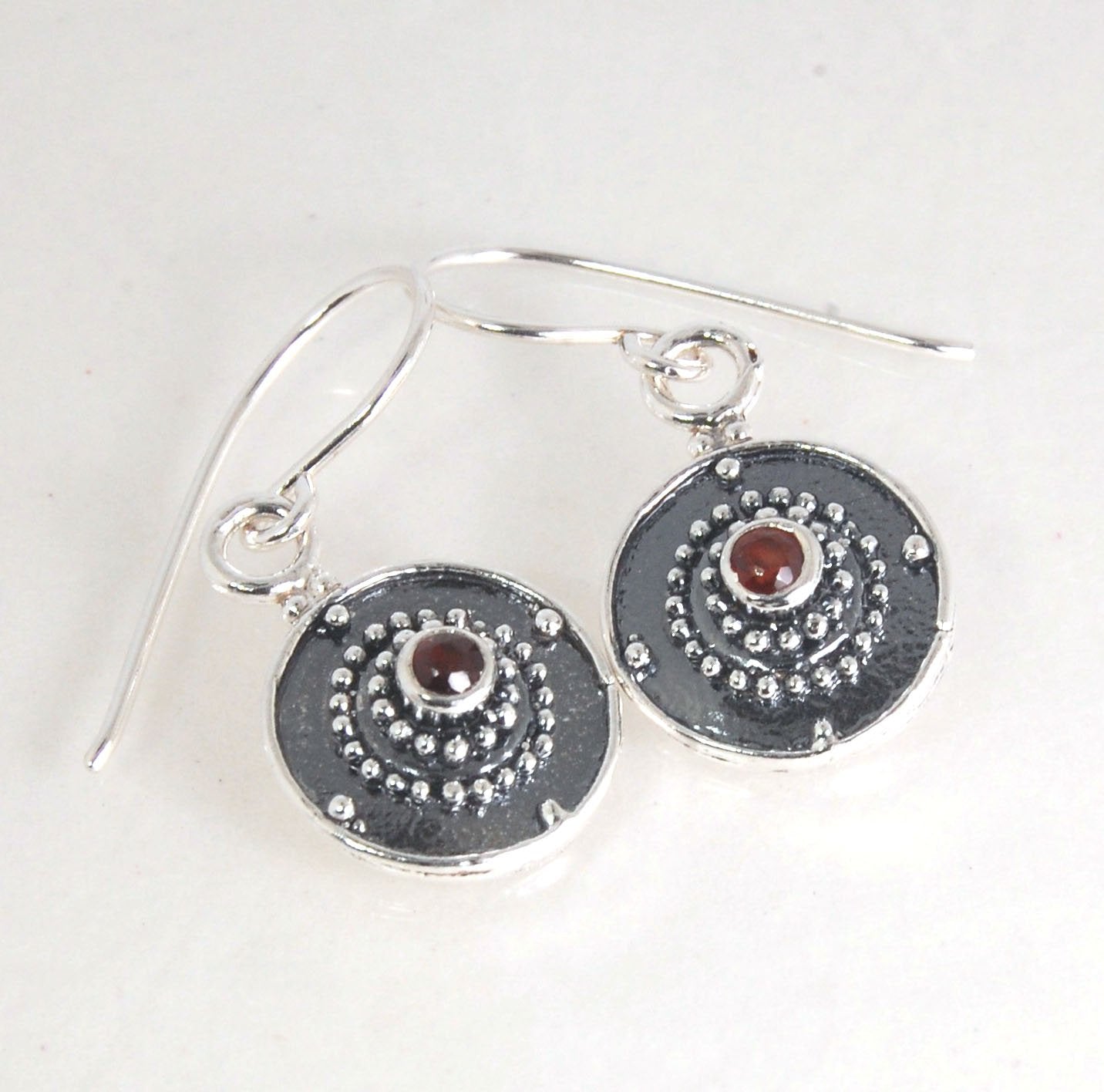 Dangle Shield Earrings in Sterling with Pink Garnet, Red Garnet, Blue Topaz, Peridot, or Amethyst These terrific shield earrings are cast from a granulated original. and is cast using the lost wax process. You can choose which stone to set in your sterlin