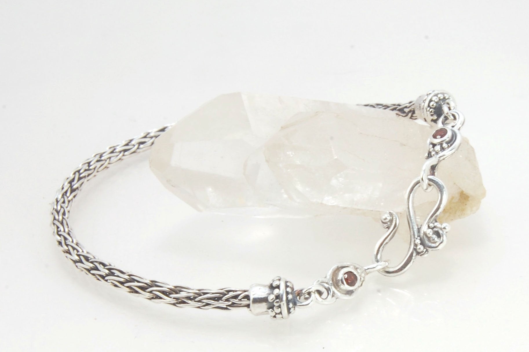 Garnet Wisteria Viking Knit Woven Silver Bracelet These woven bracelets are hand-woven in Viking knit style from fine silver with a cast granulated cap, garnet set Wisteria settings and a sterling S clasp. This chain takes many hours to make. The original