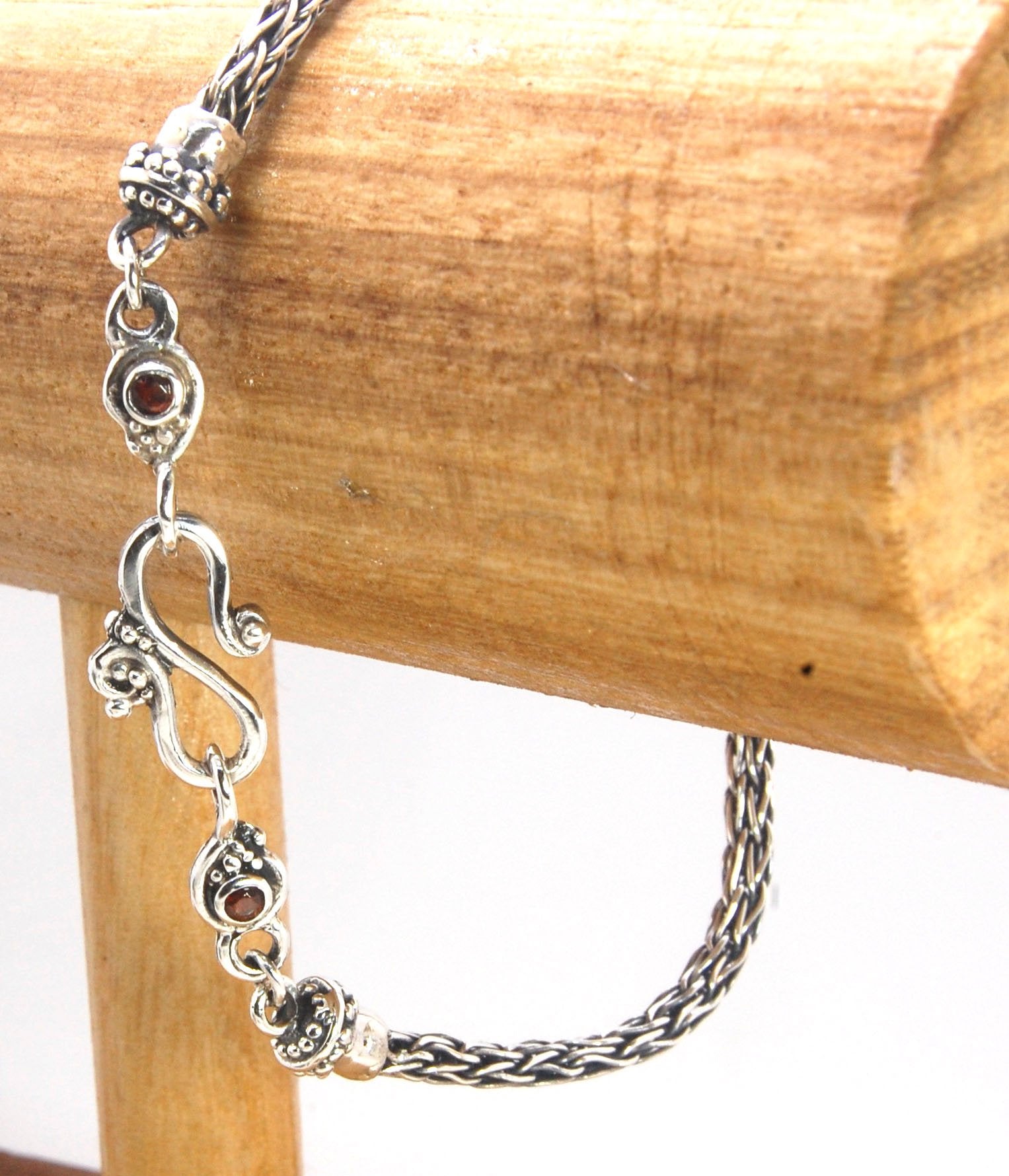 Garnet Wisteria Viking Knit Woven Silver Bracelet These woven bracelets are hand-woven in Viking knit style from fine silver with a cast granulated cap, garnet set Wisteria settings and a sterling S clasp. This chain takes many hours to make. The original
