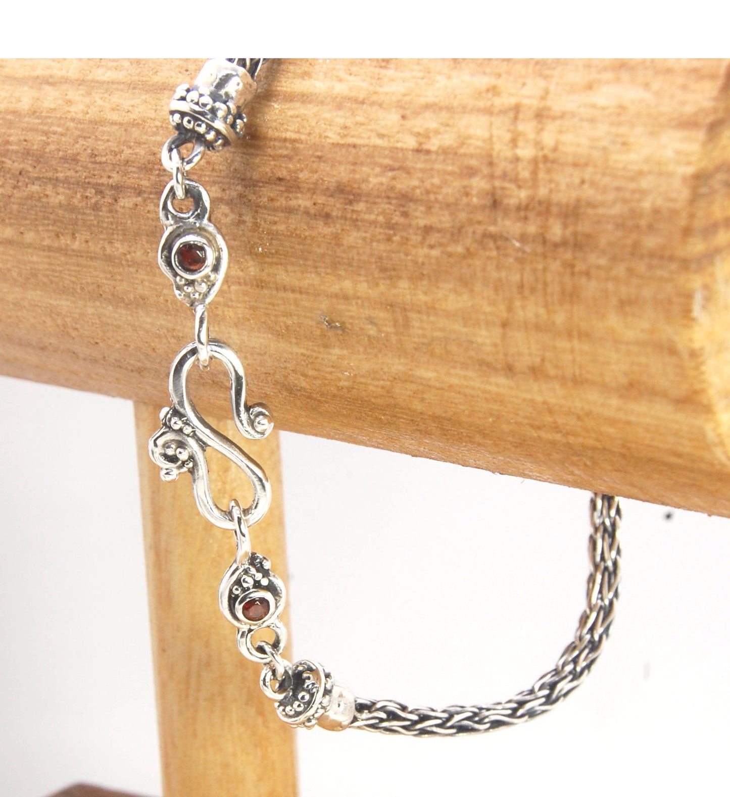 Garnet Wisteria Viking Knit Woven Silver Bracelet These woven bracelets are hand-woven in Viking knit style from fine silver with a cast granulated cap, garnet set Wisteria settings and a sterling S clasp. This chain takes many hours to make. The original