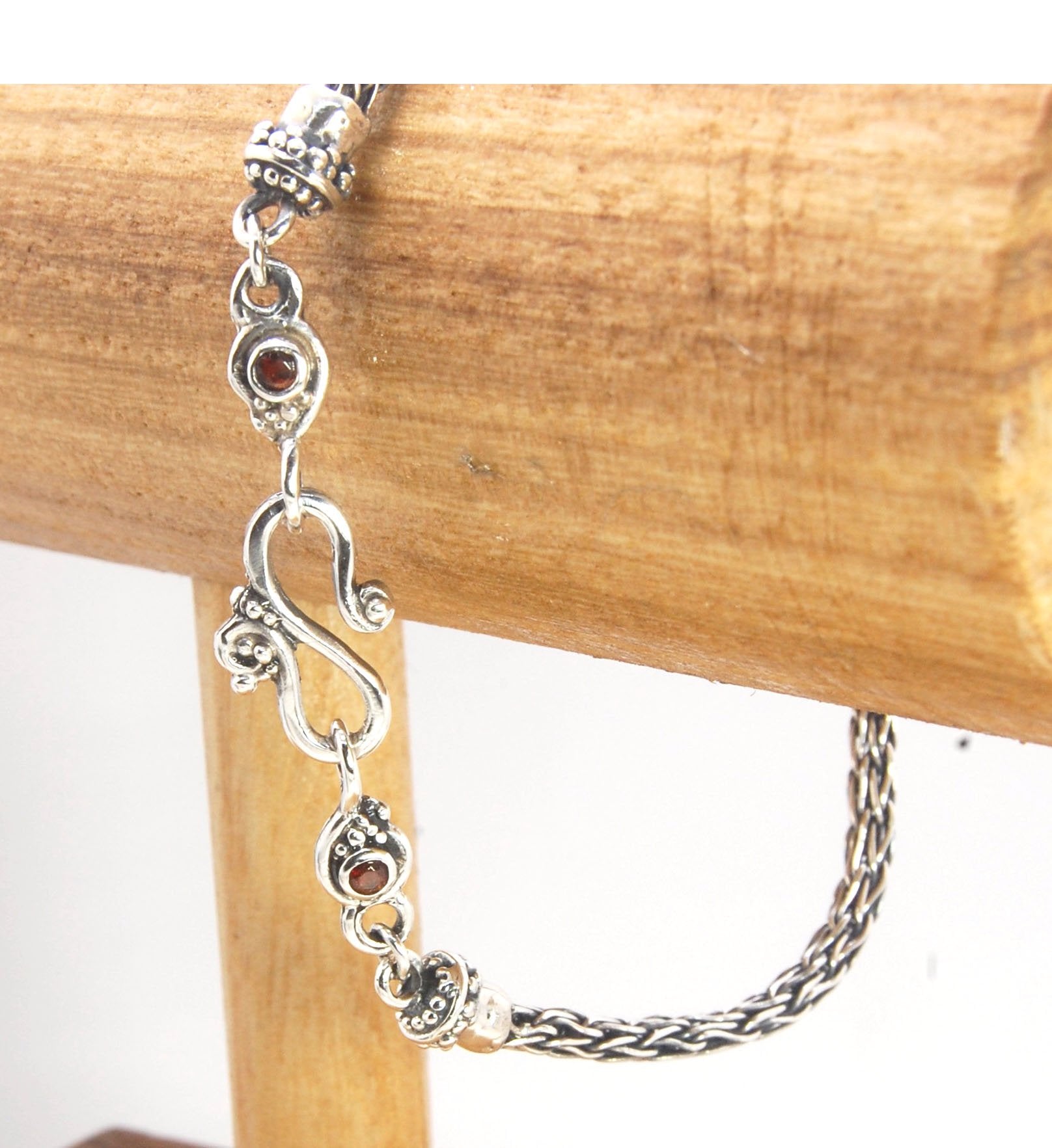 Garnet Wisteria Viking Knit Woven Silver Bracelet These woven bracelets are hand-woven in Viking knit style from fine silver with a cast granulated cap, garnet set Wisteria settings and a sterling S clasp. This chain takes many hours to make. The original
