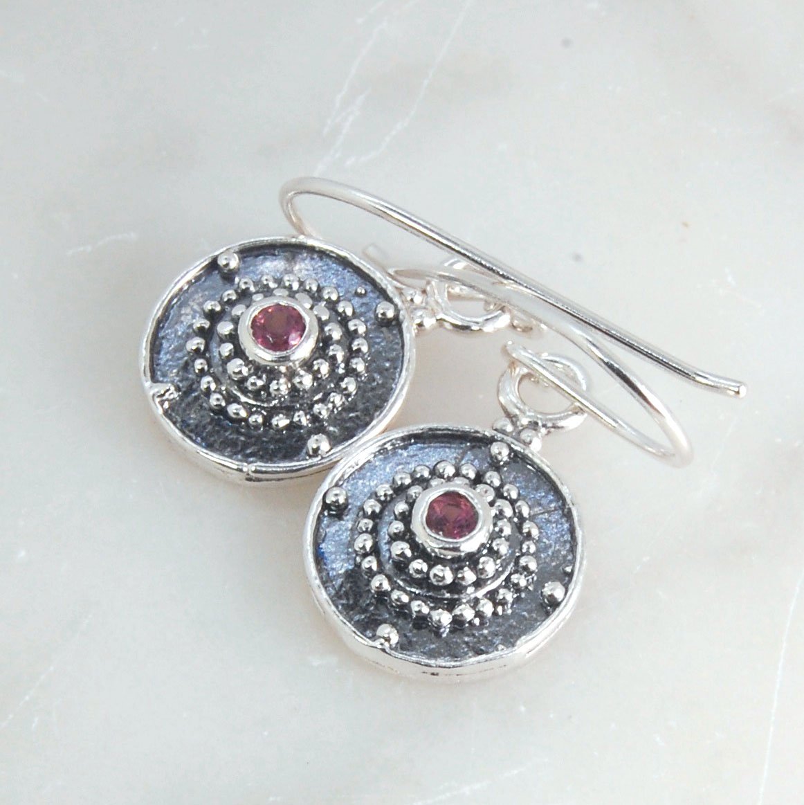 Dangle Shield Earrings in Sterling with Pink Garnet, Red Garnet, Blue Topaz, Peridot, or Amethyst These terrific shield earrings are cast from a granulated original. and is cast using the lost wax process. You can choose which stone to set in your sterlin