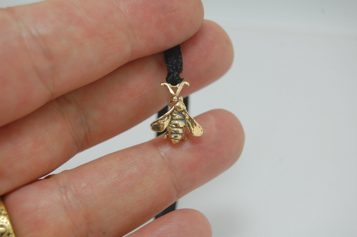 Bee Pendant in 14k gold These bees were so fun to carve!Carved in wax and cast using a lost-wax process in 14k gold. I finish the bee with a dark patina in the recess and attach an oxidized sterling chain length of your specification. I then give the bee