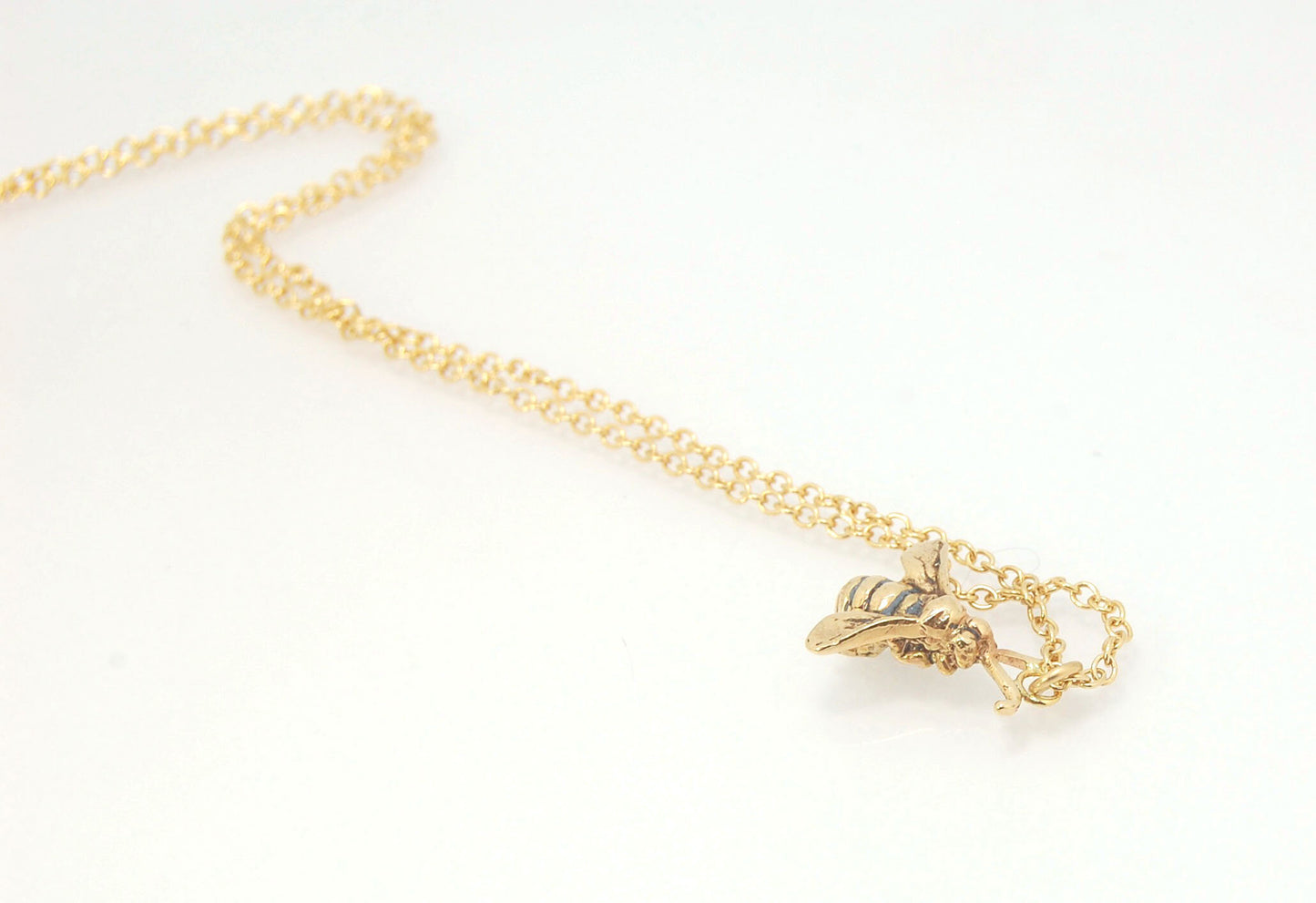 Bee Pendant in 14k gold These bees were so fun to carve!Carved in wax and cast using a lost-wax process in 14k gold. I finish the bee with a dark patina in the recess and attach an oxidized sterling chain length of your specification. I then give the bee