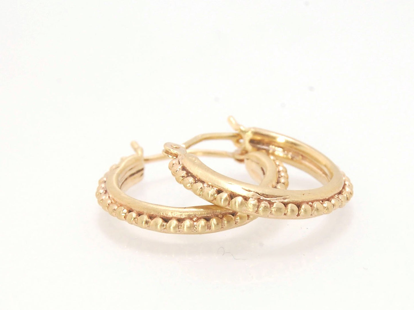 Etruscan hoops in 14k Gold - Medium These 14k yellow gold hoops are cast in my studio from a granulated master for a limited edition series of hoops. I use fine silver for the original granulation, then make a mold, pull a wax copy from the mold, then cas