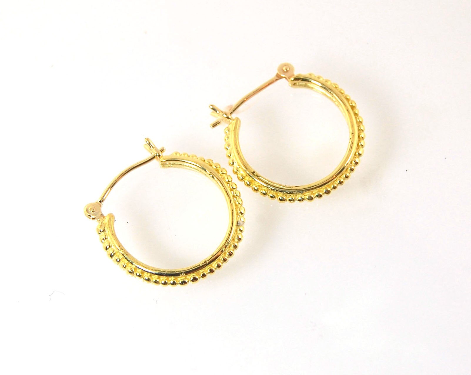 Etruscan hoops in 14k Gold - Medium These 14k yellow gold hoops are cast in my studio from a granulated master for a limited edition series of hoops. I use fine silver for the original granulation, then make a mold, pull a wax copy from the mold, then cas