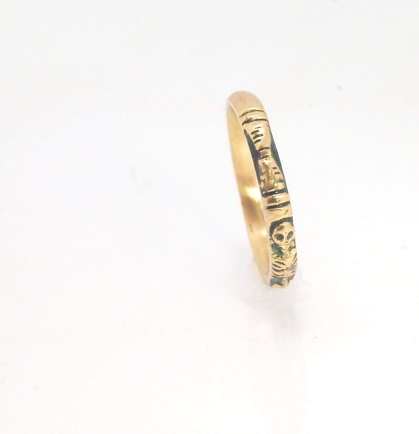 Memento Mori Skeleton Ring in 14k gold - 3mm This is the most narrow of my Memento Mori rings at 3mm wide and is cast in 14k rich yellow gold. The Skeleton is flanked by intertwined hearts on one side.14k rich yellow gold and EnamelMade to Order. Usually