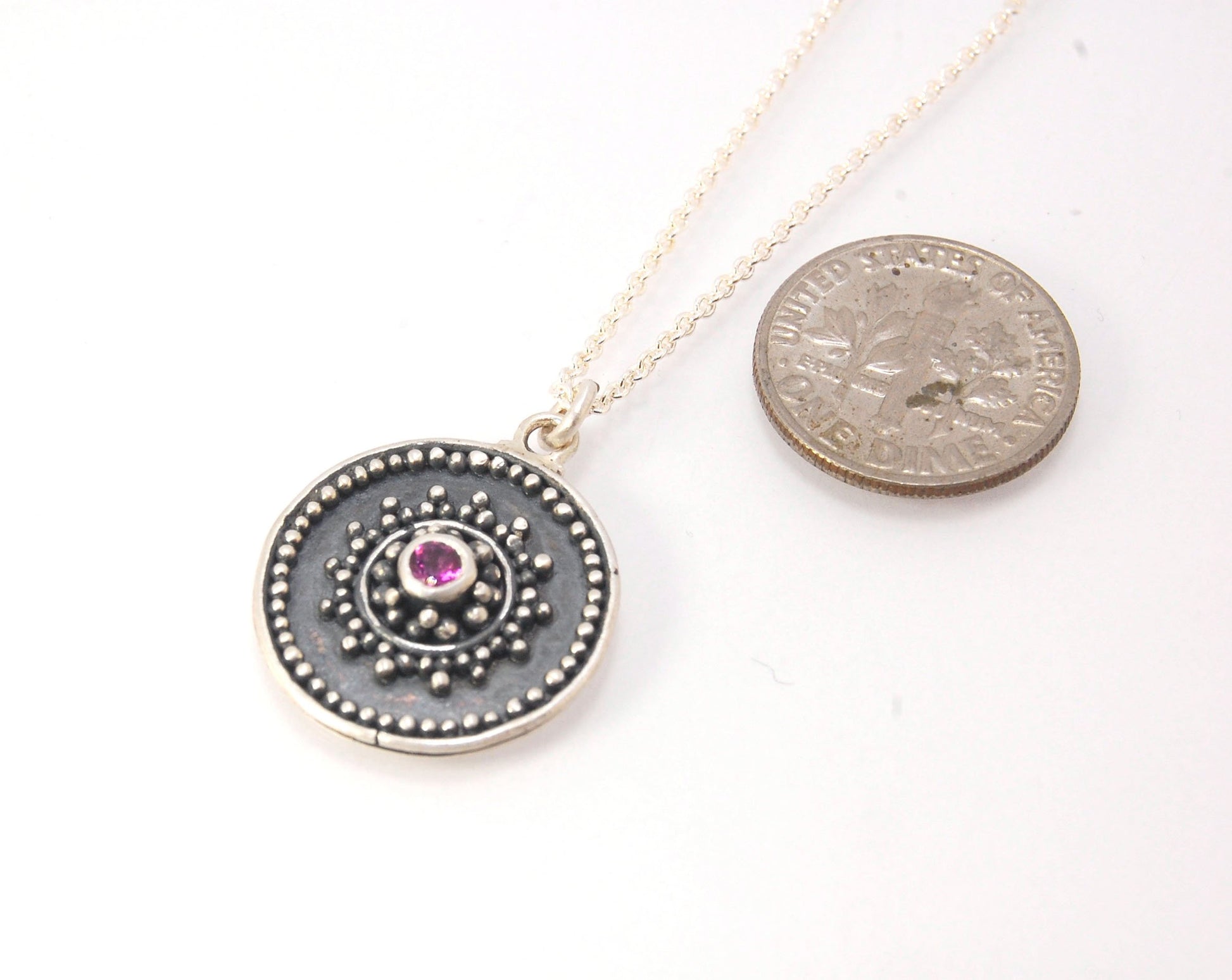 Pink Tourmaline Granulated Disk Pendant Faceted Pink Tourmaline bezel-set in Fine Silver Granulation.Granulation is a controlled fusing process that has been utilized for thousands of years. I melt 999.99% Fine Silver to create granules and wire. The gran