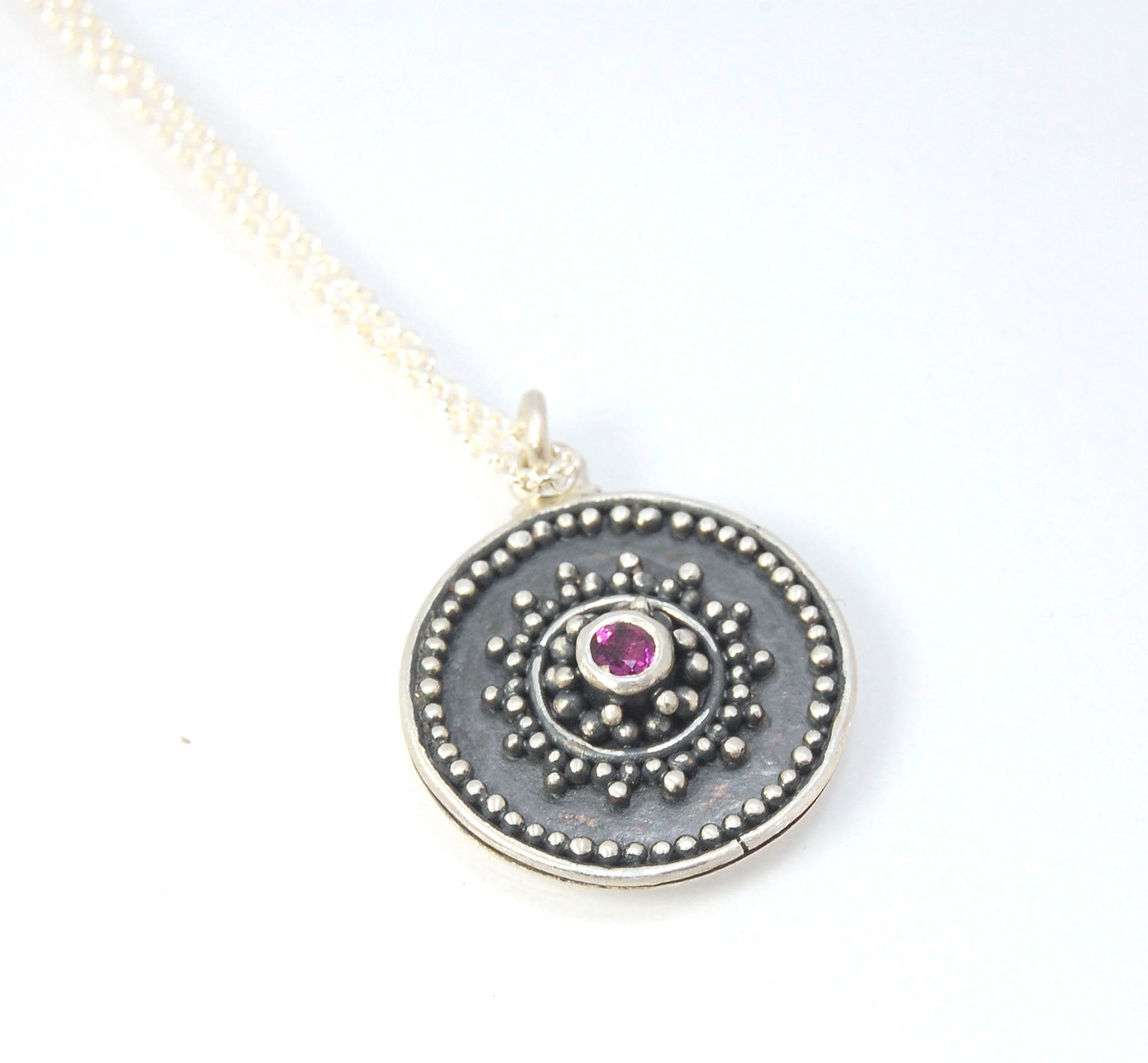 Pink Tourmaline Granulated Disk Pendant Faceted Pink Tourmaline bezel-set in Fine Silver Granulation.Granulation is a controlled fusing process that has been utilized for thousands of years. I melt 999.99% Fine Silver to create granules and wire. The gran