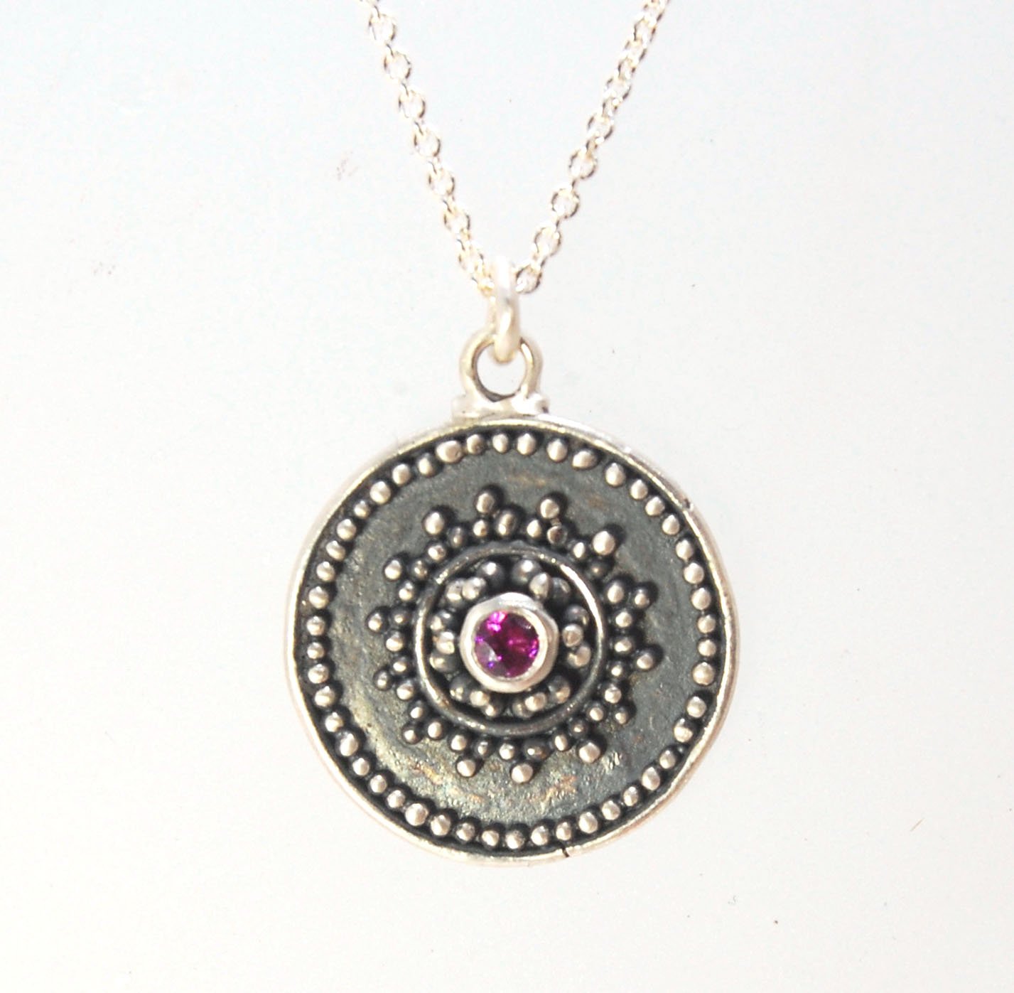 Pink Tourmaline Granulated Disk Pendant Faceted Pink Tourmaline bezel-set in Fine Silver Granulation.Granulation is a controlled fusing process that has been utilized for thousands of years. I melt 999.99% Fine Silver to create granules and wire. The gran