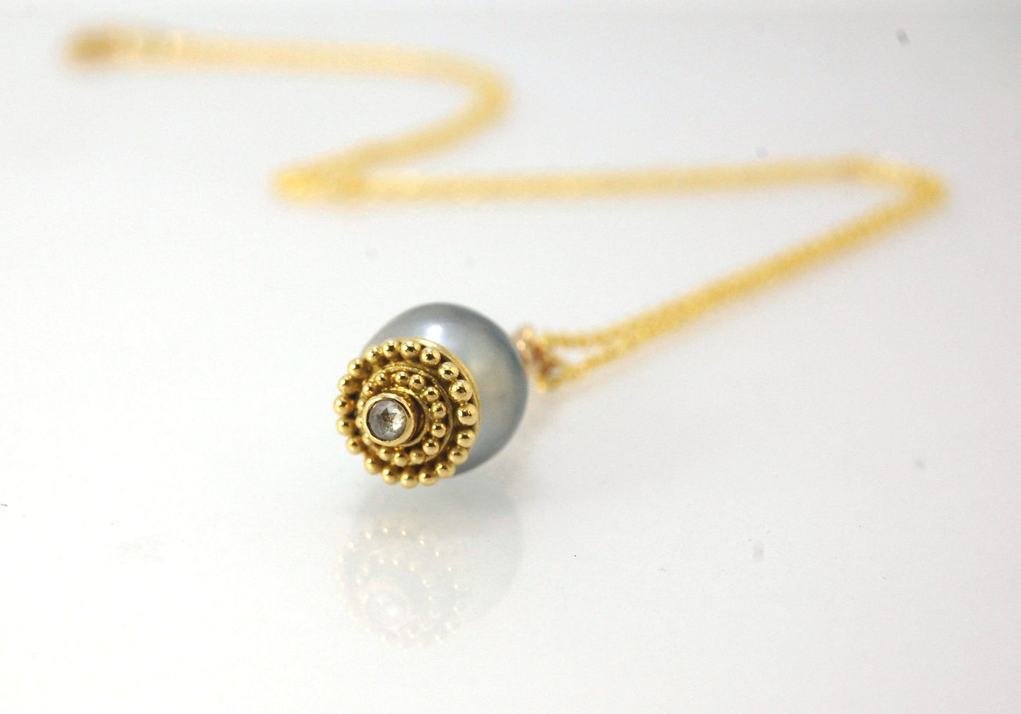Baroque Grey Pearl with 18k gold Granulation and a Rosecut Diamond Ok this one is a stunner. 18k gold Granulated Dome with a 2.5 mm Rosecut Diamond and Granulated Bail pictured on an 18” peacock black oxidized Sterling Silver chain. Granulation is an anci