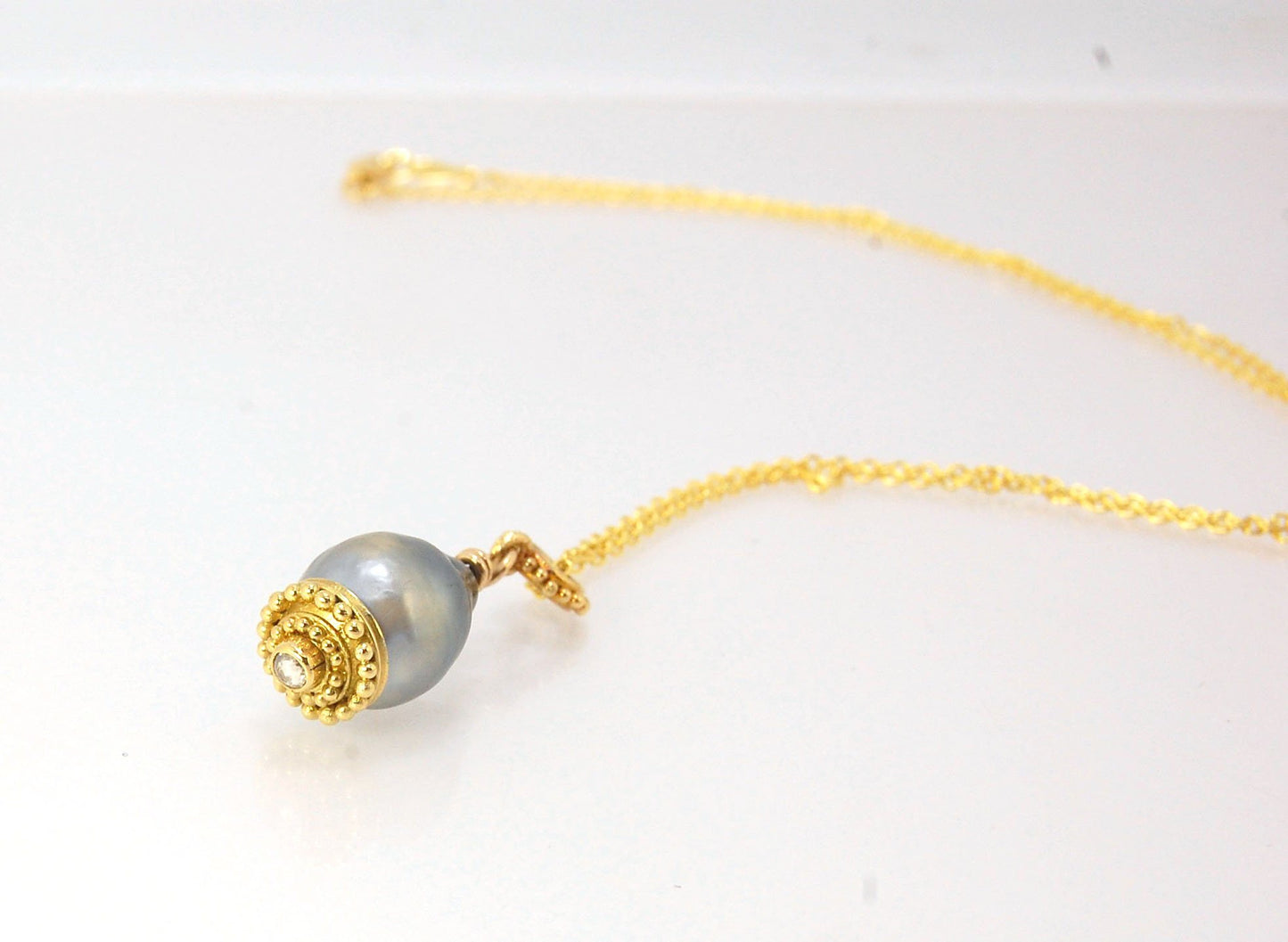 Baroque Grey Pearl with 18k gold Granulation and a Rosecut Diamond Ok this one is a stunner. 18k gold Granulated Dome with a 2.5 mm Rosecut Diamond and Granulated Bail pictured on an 18” peacock black oxidized Sterling Silver chain. Granulation is an anci