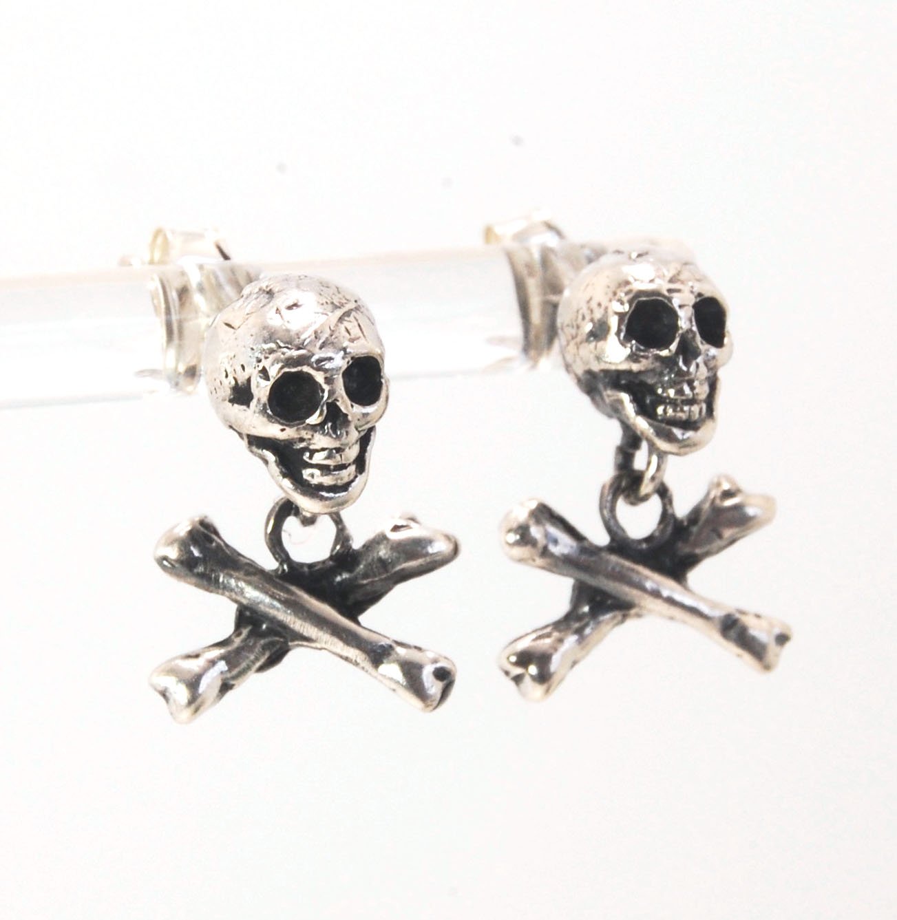 Skull & Bones Dangle Post Earrings These solid sterling silver Skull & Bones dangle earrings are wax carved by hand and cast using the ancient process of Lost Wax to cast them in sterling silver. I then made a mold, which I can inject with wax and make wa