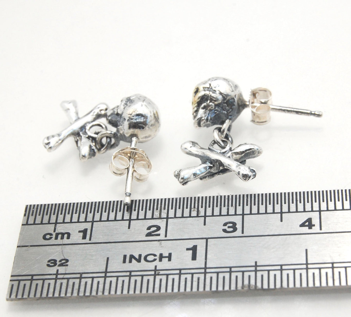 Skull & Bones Dangle Post Earrings These solid sterling silver Skull & Bones dangle earrings are wax carved by hand and cast using the ancient process of Lost Wax to cast them in sterling silver. I then made a mold, which I can inject with wax and make wa