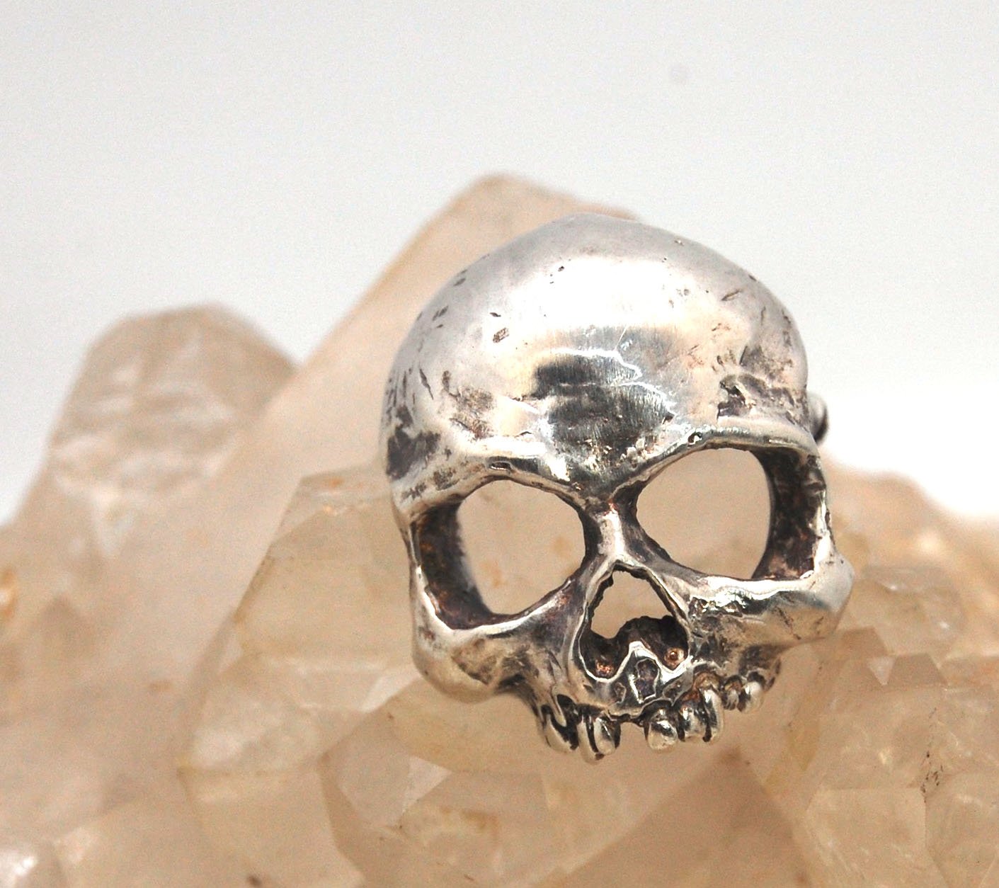 Through the Veil Darkly Skull Face Pin This Through the Veil Darkly Skull Face pin in Sterling Silver has a lot of expression and a nice weight with a hinged pin stem and clasp. It’s not too big or too small or too heavy. It will look great on your sweate