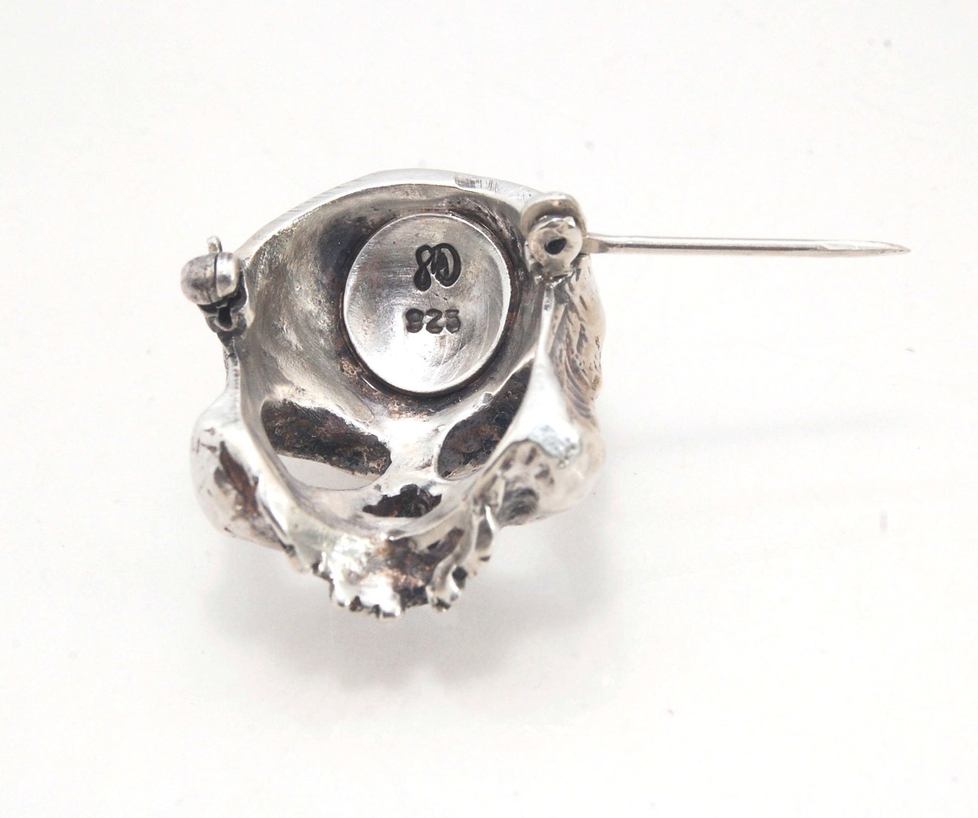 Through the Veil Darkly Skull Face Pin This Through the Veil Darkly Skull Face pin in Sterling Silver has a lot of expression and a nice weight with a hinged pin stem and clasp. It’s not too big or too small or too heavy. It will look great on your sweate